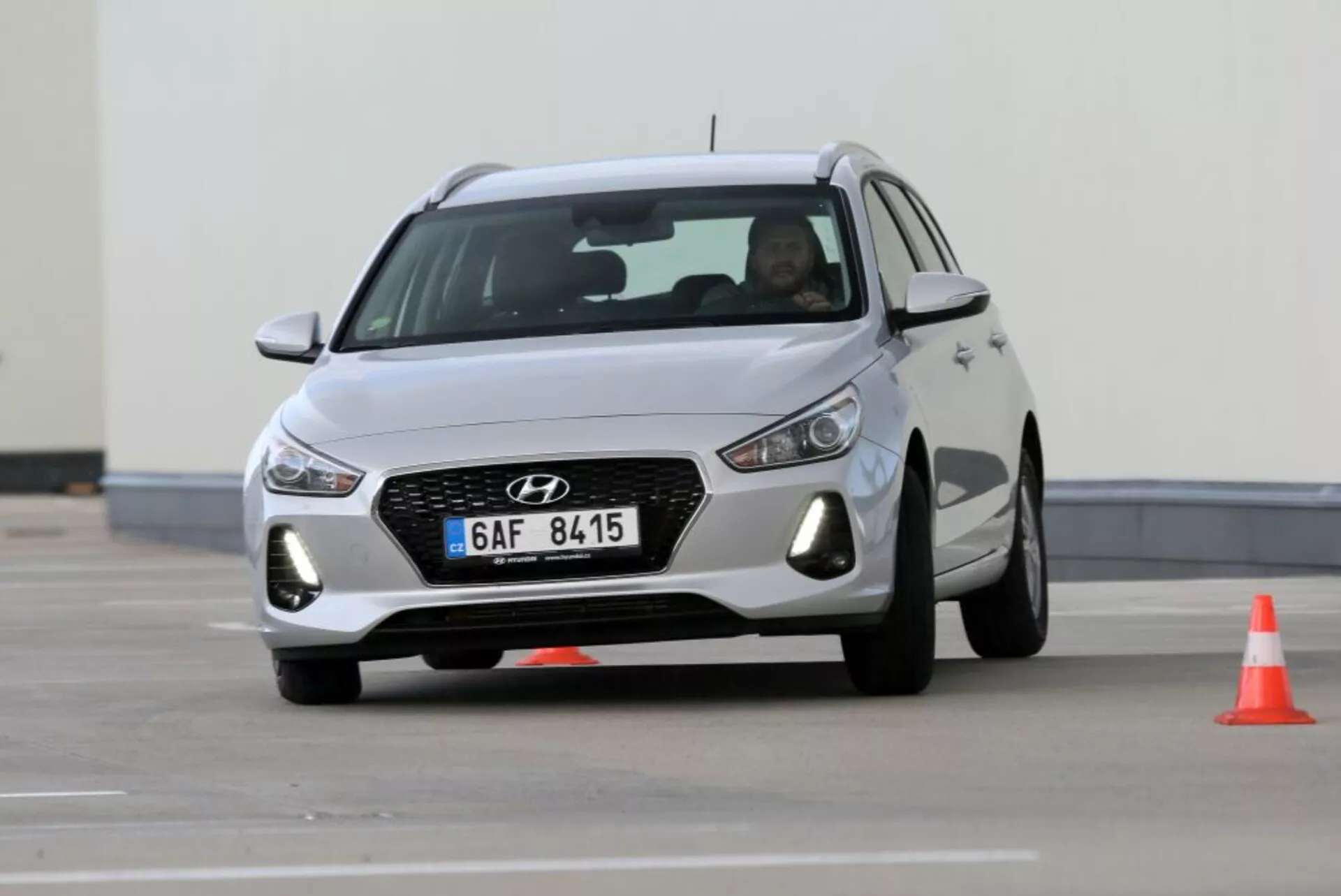 Hyundai i30 N z 2017 roku w ruchu, prezentujący przedni grill z heksagonalnym wzorem i chromowanym obrysem, reflektory LED i aerodynamiczny design z felgami aluminiowymi, uchwycony na torze jazdy
