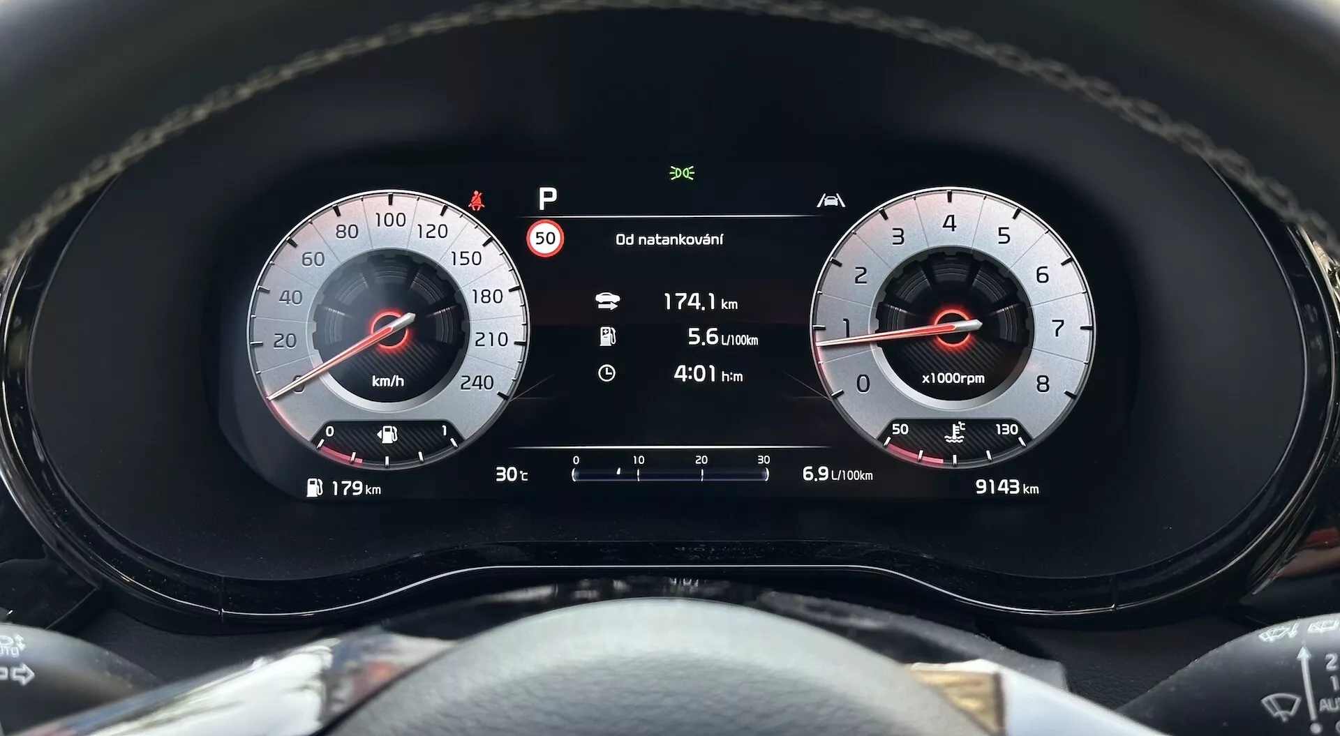 Zbliżenie na zestaw wskaźników Kia XCeed 2022 podkreślające prędkościomierz, obrotomierz i wyświetlacz cyfrowy z wskaźnikiem trybu parkowania, odległość podróży, ekonomię paliwa i całkowity odczyt przebiegu