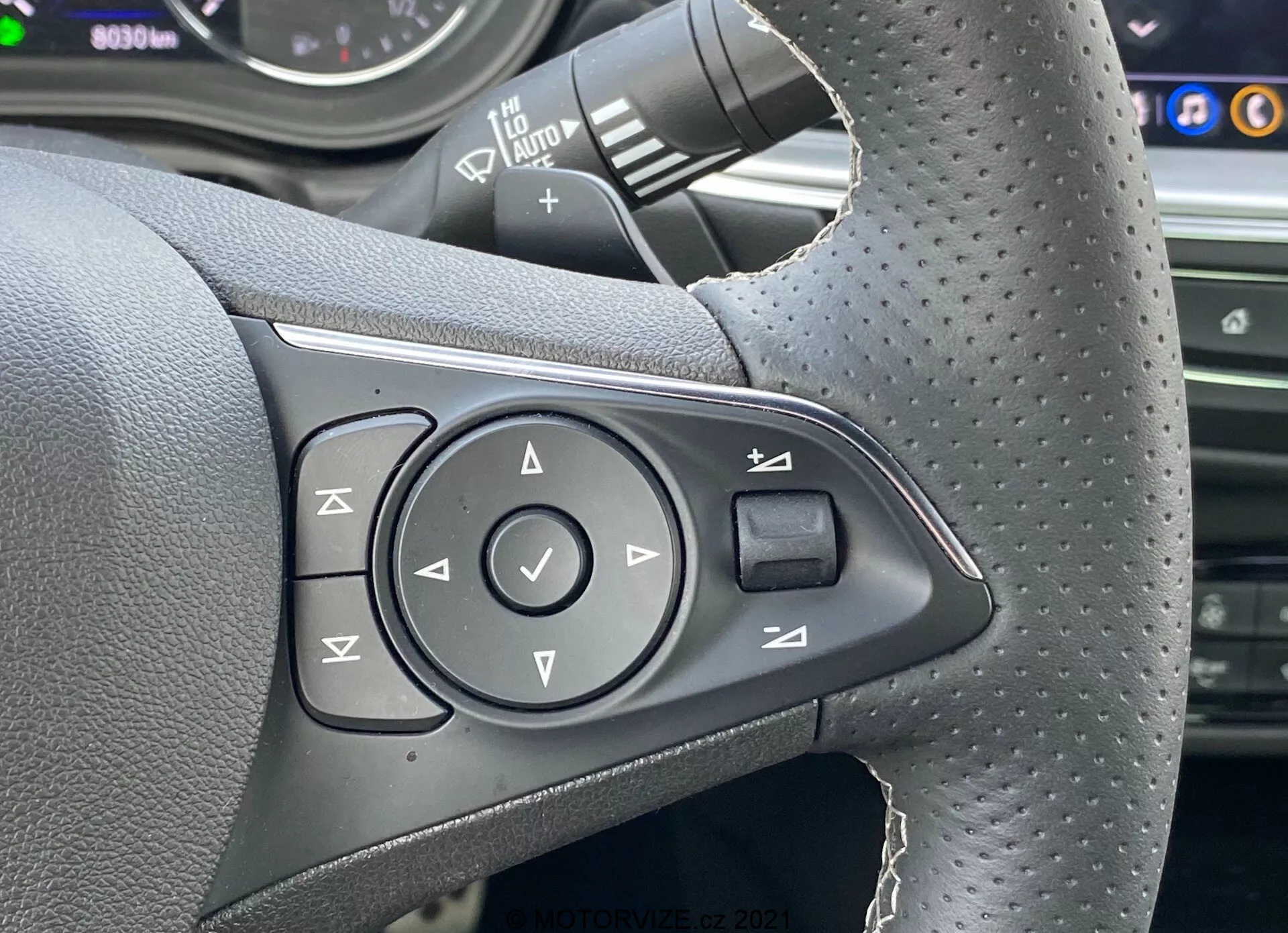 Widok z boku na Opel Insignia GSi Grand Sport 2020 w ruchu, ukazujący swoje eleganckie aerodynamiczne linie, wyrafinowane reflektory LED i sportowe felgi aluminiowe