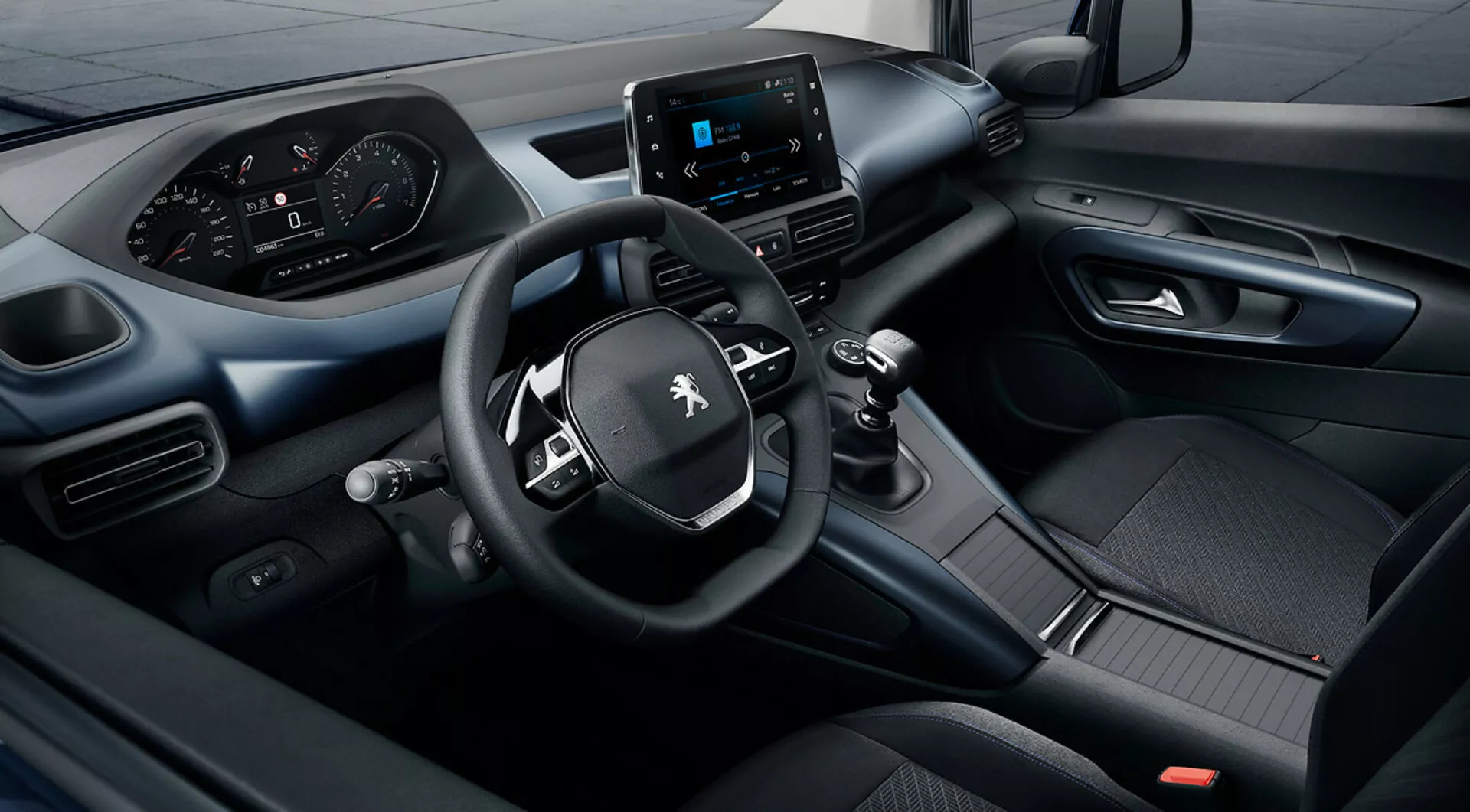 Podwyższony widok wnętrza Peugeot Rifter 2018 z systemem infotainment na ekranie dotykowym, cyfrowym kokpitem i kierownicą trójramienną z zintegrowanymi kontrolkami, podkreślający doskonałość technologiczną i projektową