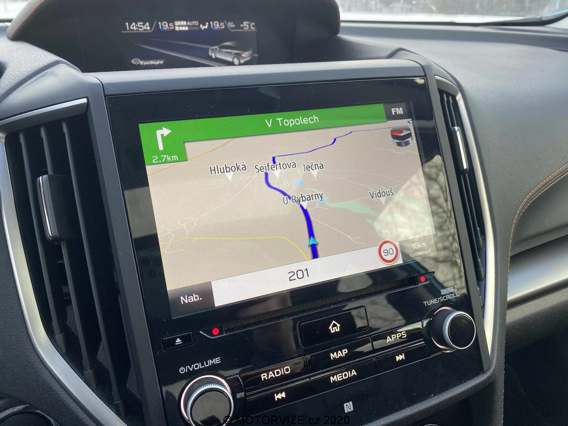 Centralna konsola Subaru XV 2018 skupiająca się na systemie infotainment, wyświetlająca mapę nawigacji na ekranie, z przyciskami do regulacji głośności, radia, multimediów, aplikacji i ustawień samochodu, dodatkowe elementy sterujące klimatyzacją częściowo widoczne, pokazujące trasę GPS, czas (14:54), temperaturę zewnętrzną (-5,5°C), wskaźniki łączności sugerujące funkcjonalność Bluetooth lub Wi-Fi, podkreślająca nowoczesną technologię motoryzacyjną.