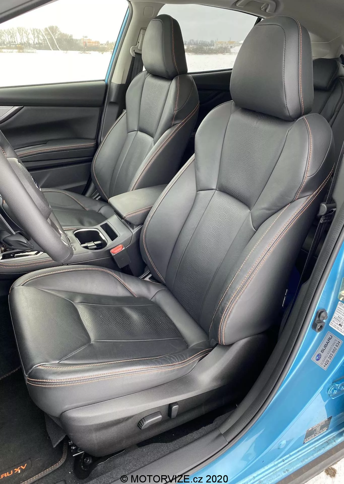 Wnętrze Subaru XV 2018 1.6i Trend Lineartronic z przednimi fotelami kierowcy i pasażera tapicerowanymi czarną skórą z czerwonymi przeszyciami, widok z zewnątrz od strony kierowcy z otwartymi drzwiami.