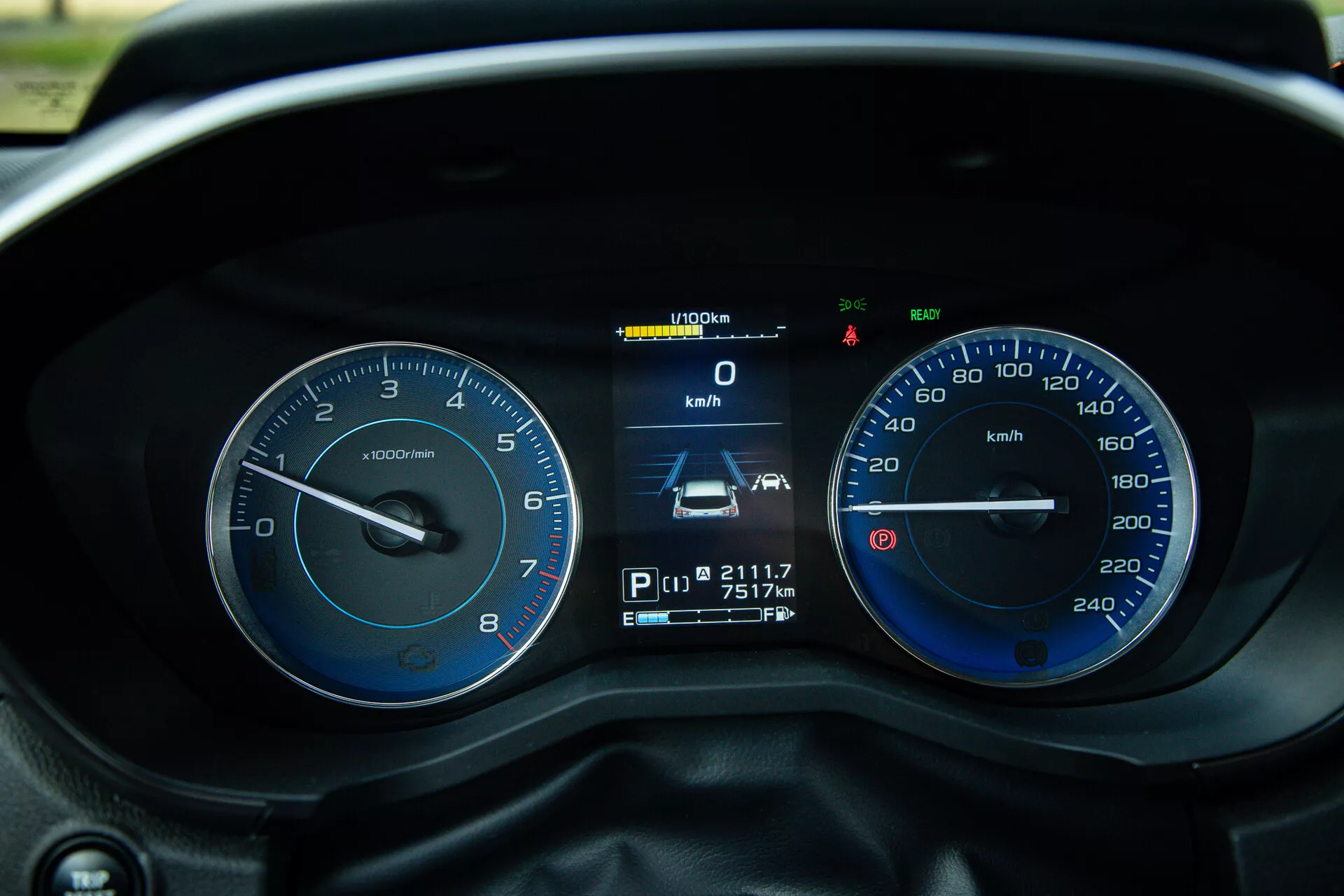Zbliżony widok deski rozdzielczej Subaru XV 2021 z perspektywy kierowcy, pokazujący szczegóły takie jak obrotomierz, prędkościomierz, wyświetlacz cyfrowy z prędkością, pozycją biegu, odczytem licznika kilometrów i licznika przejazdu, a także różne wskaźniki i światła ostrzegawcze