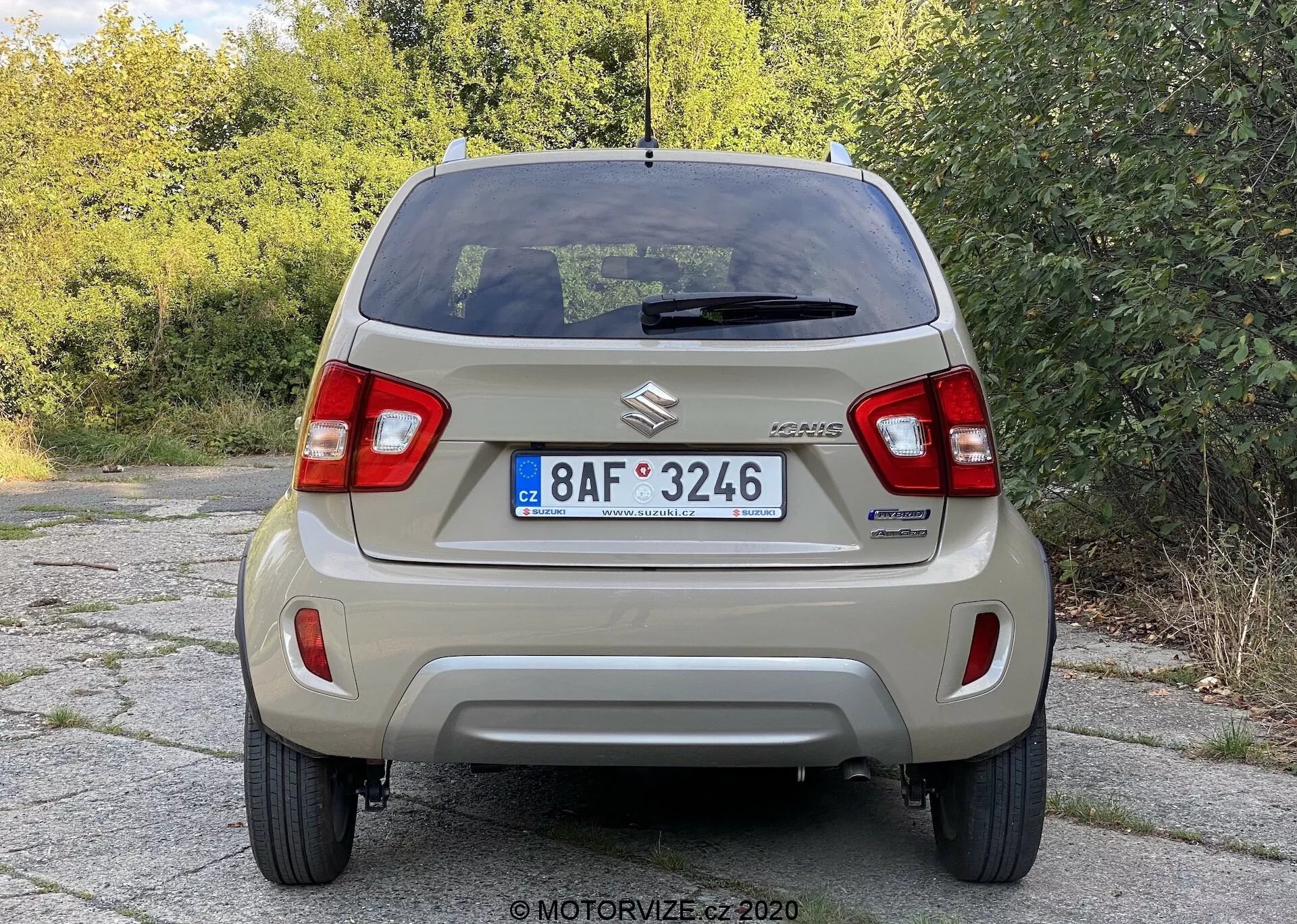 Widok tylny Suzuki Celerio, ukazujący wyraźne szczegóły, w tym znaczek Suzuki, oznaczenie CELERIO, pionowe zespoły świateł tylnych, prosty tylny zderzak, europejski numer rejestracyjny, tylne okno z odmrażaczem i centralnie umieszczonym trzecim światłem stopu, tylna wycieraczka, antena dachowa, standardowe stalowe felgi z kołpakami oraz prosty układ wydechowy, ilustrujący konstrukcję podstawowego samochodu miejskiego.