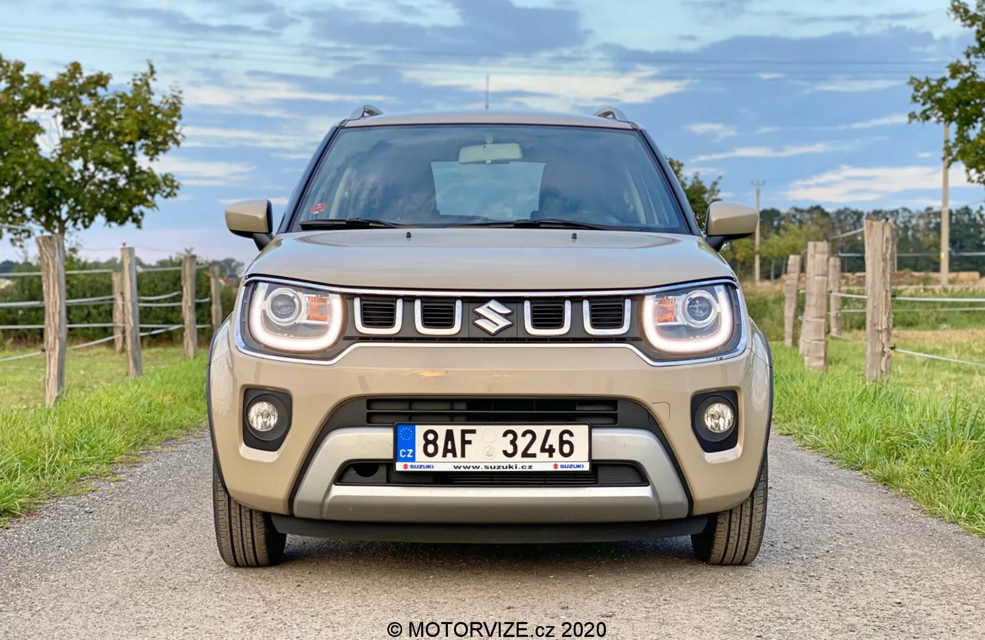 Widok z przodu i boku na Suzuki Ignis 2020 1.2 Dualjet Hybrid Club w środowisku miejskim, podkreślający jego kompaktowy design, nowoczesne reflektory i odważny grill.