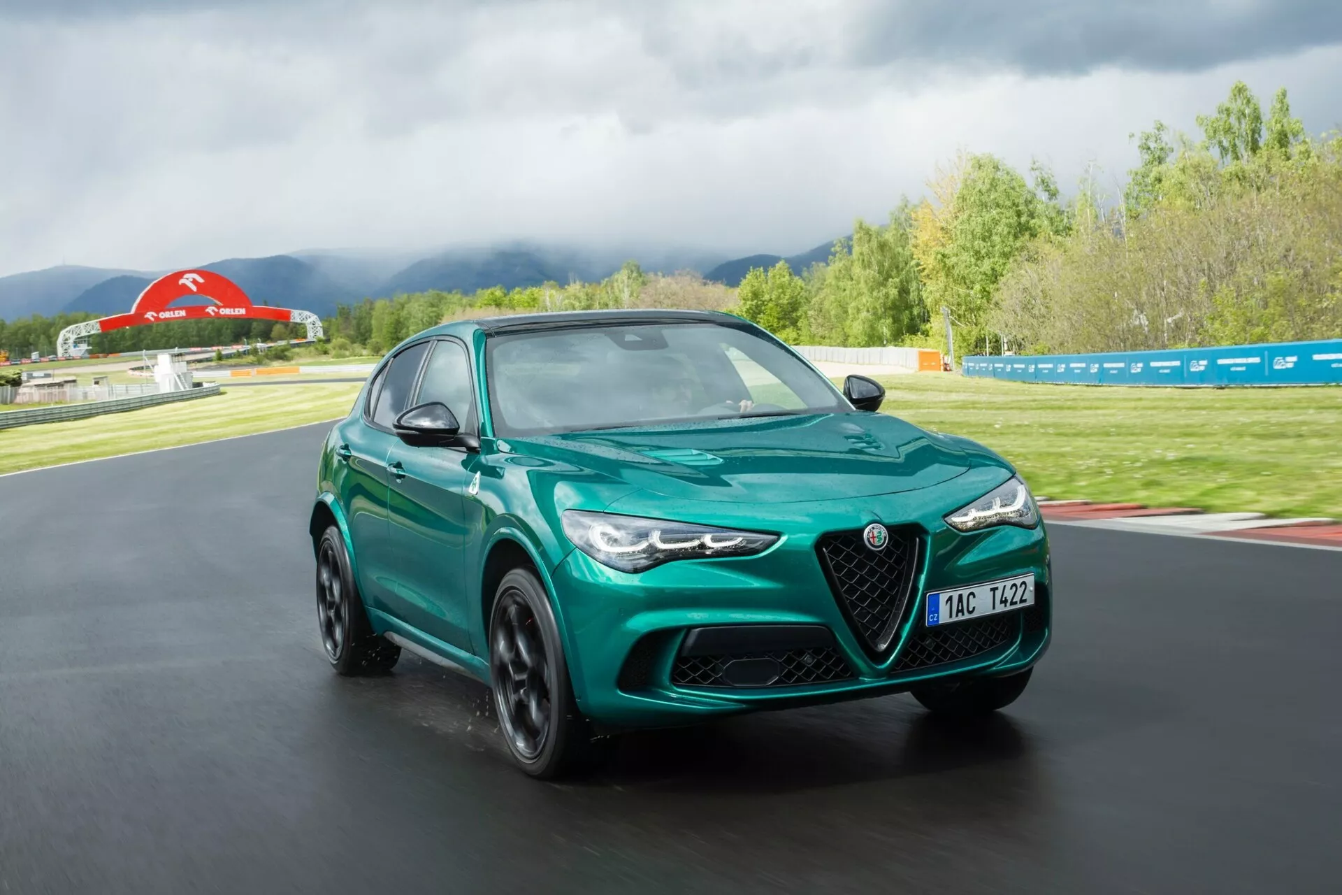 Alfa-Romeo Giulia Quadrifoglio 2023 w żywej czerwieni, prezentująca swój elegancki design, zaawansowaną aerodynamikę i mocną postawę