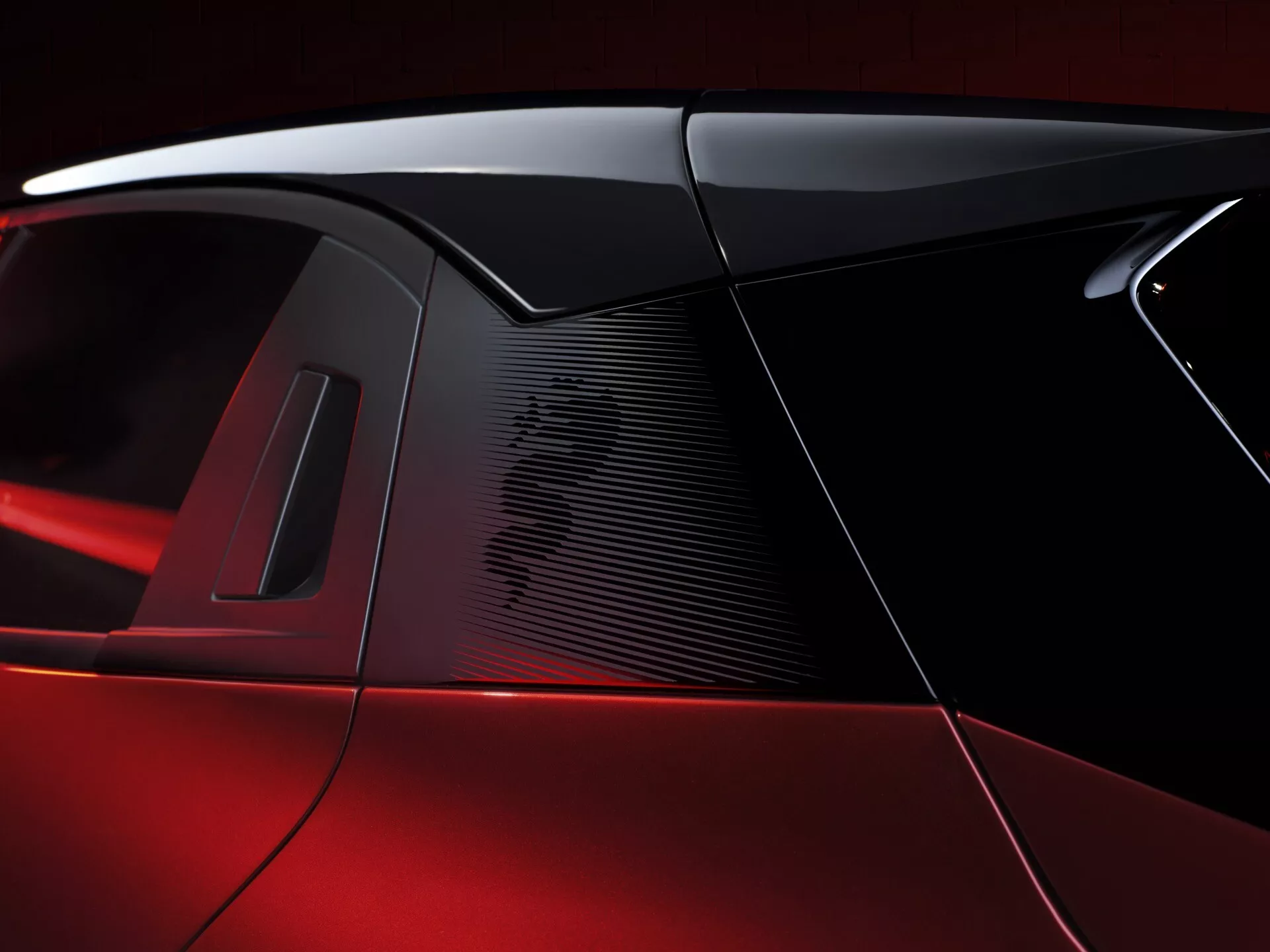 Zbliżenie na słup C Alfa Romeo Junior 2024, prezentujące perłowe czerwone wykończenie, elegancki design tylnej szyby, wysokowydajny wlot powietrza i potencjalny panoramiczny dach, podkreślając luksusowe i sportowe elementy designu.