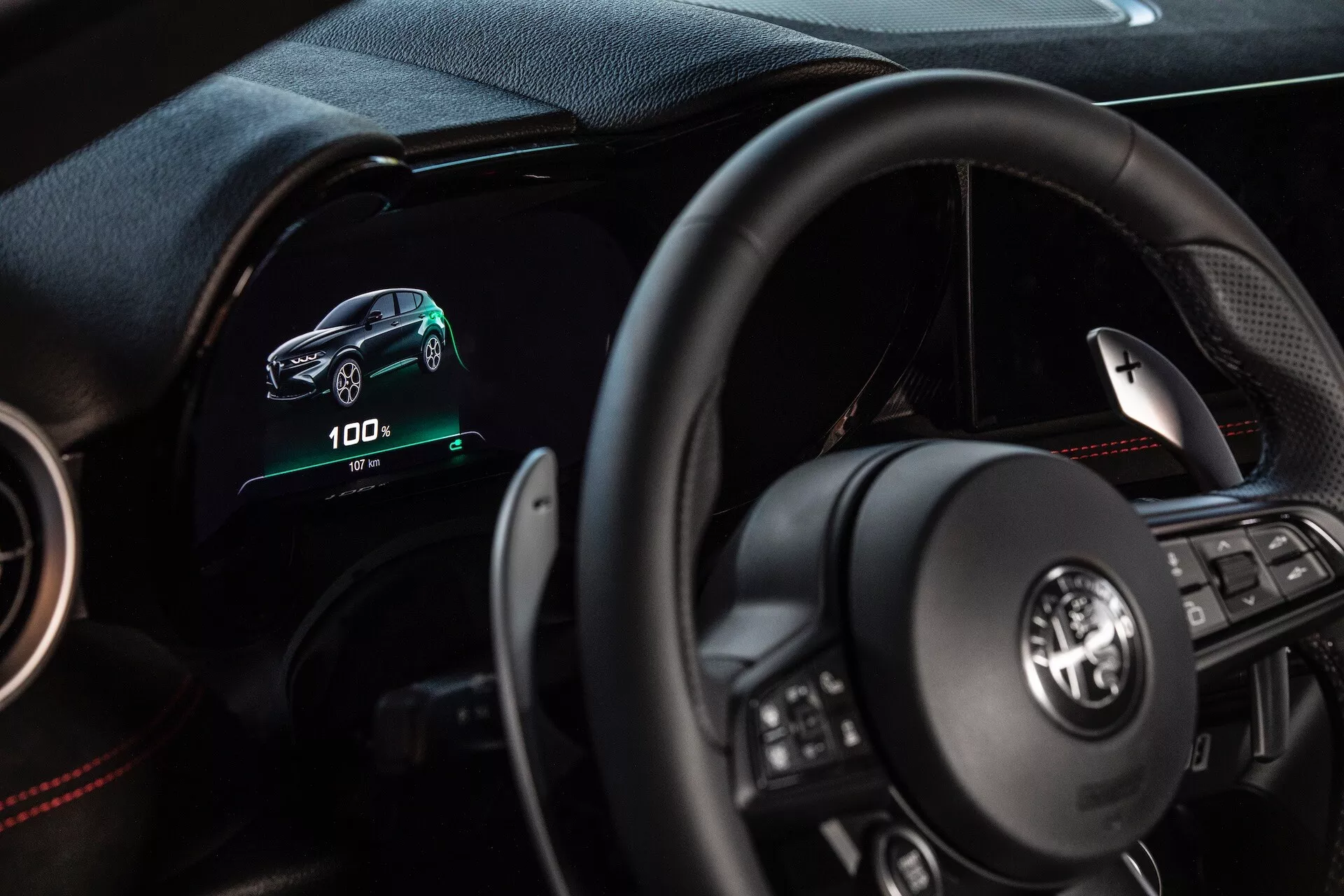 Wnętrze Alfa Romeo Tonale 2022 z perspektywy kierowcy z cyfrowym kokpitem, wielofunkcyjną kierownicą i wskaźnikami pojazdu elektrycznego