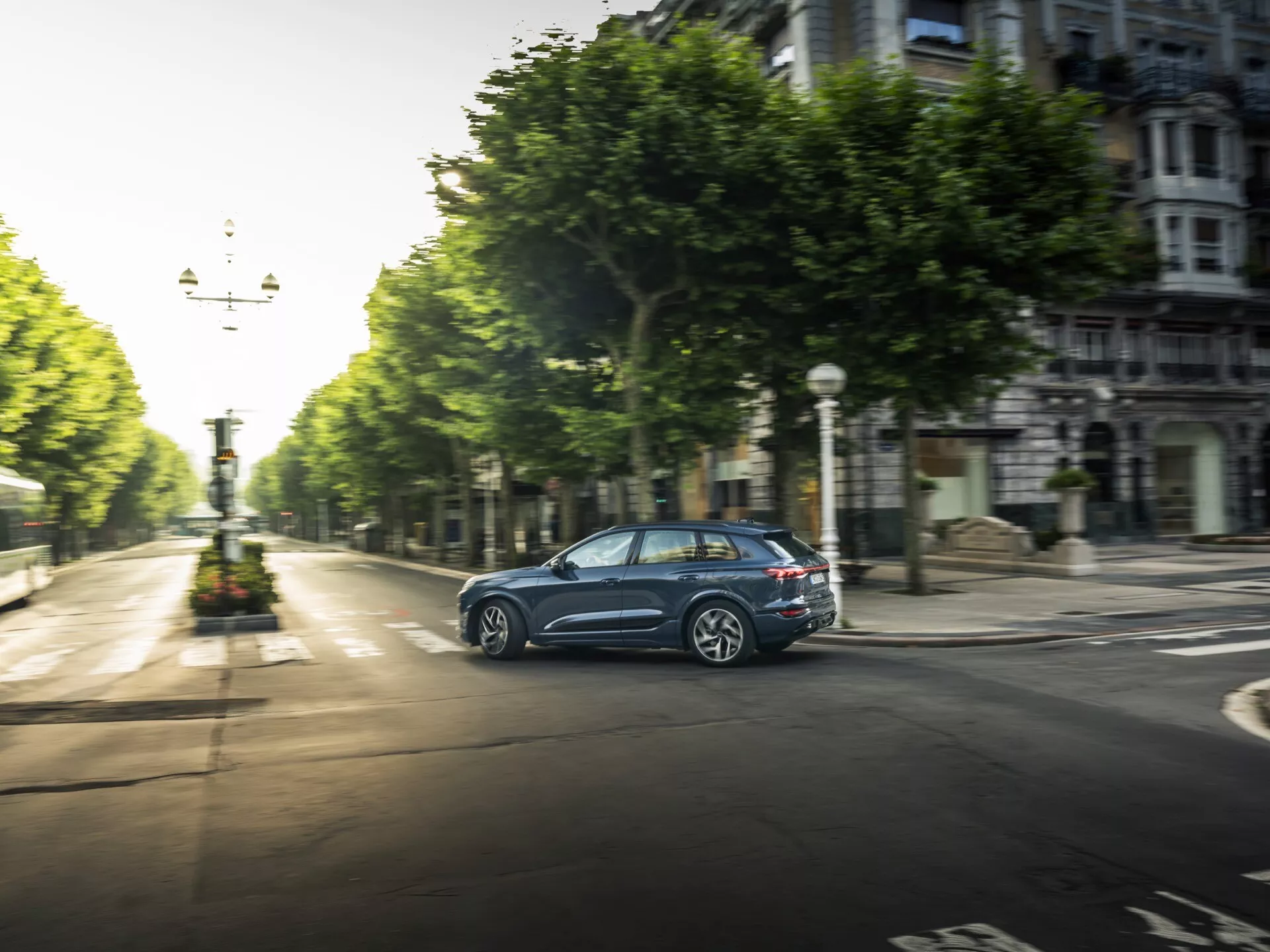 Audi Q6 e-tron 2024 luksusowy elektryczny SUV, mający elegancki, aerodynamiczny design, najnowocześniejszą technologię, wnętrza premium i zaawansowane funkcje bezpieczeństwa, sfotografowany w nowoczesnym otoczeniu miejskim.