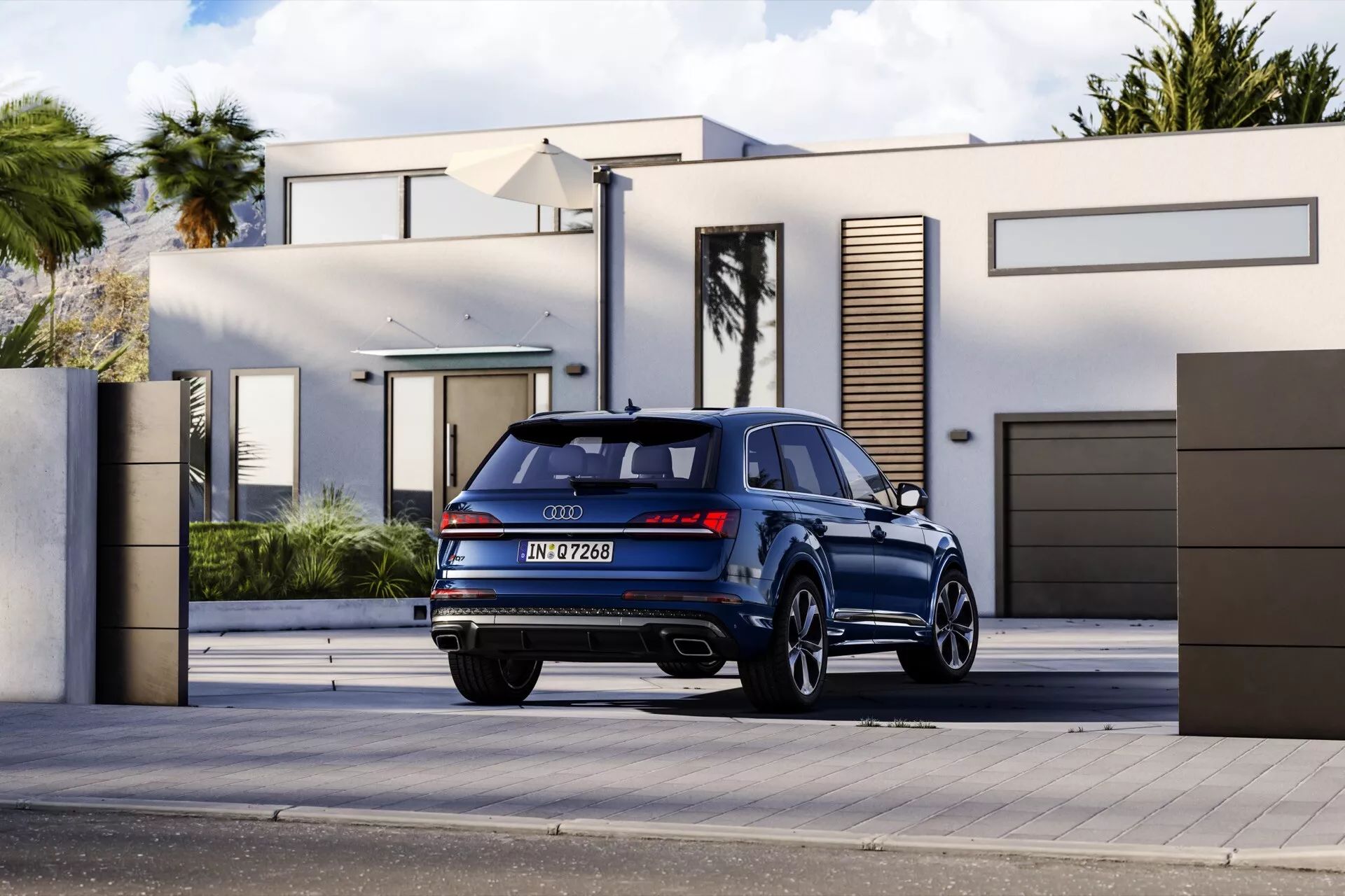 Audi Q7 4M-Facelift-2 2024 w ciemnoniebieskim metaliku na podjeździe mieszkalnym, przedstawiające elegancki design, tylnie światła LED, podwójny wydech i sportowe felgi aluminiowe z perspektywy trzy czwarte od tyłu