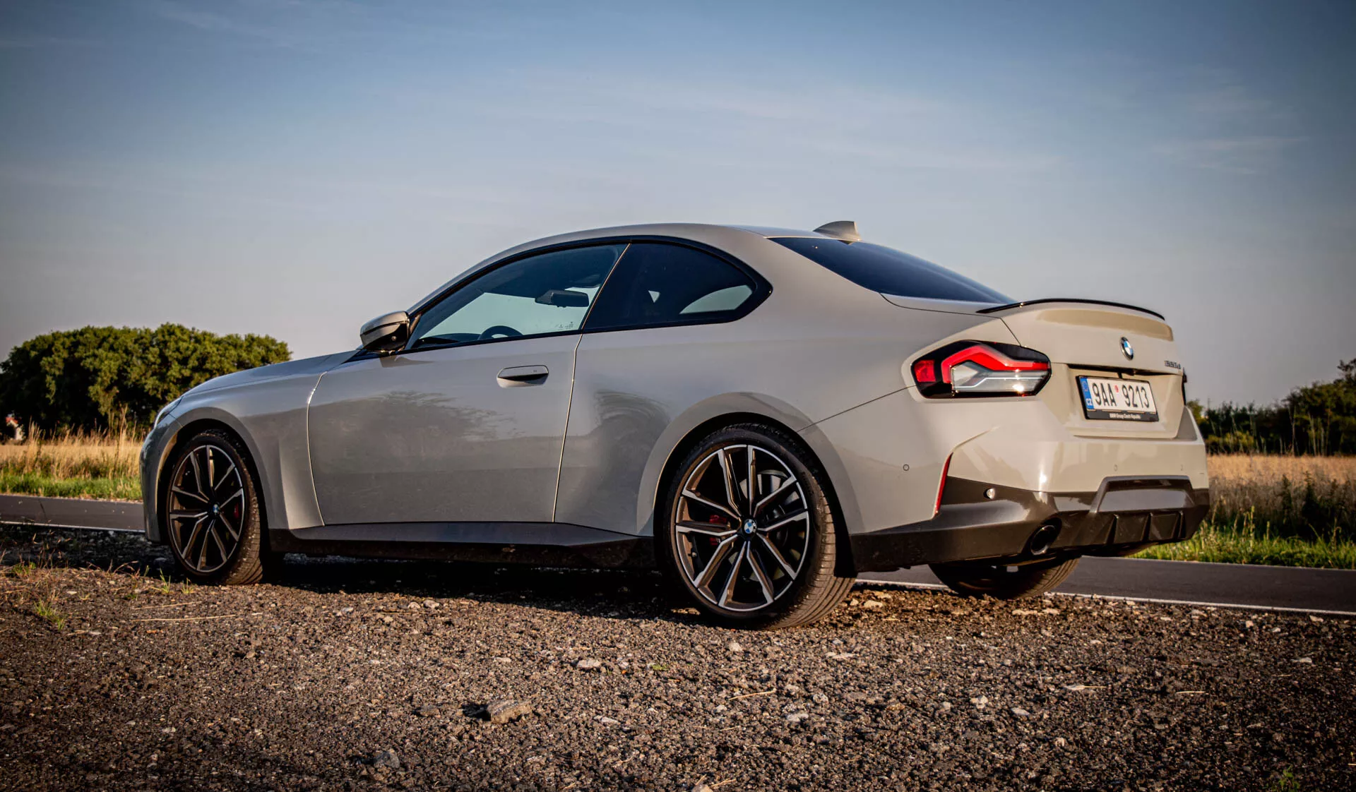 BMW Serii 2 Coupé 2022 z eleganckim opływowym designem, kultową kratką nerkową i zaawansowanymi reflektorami LED; prezentuje nowoczesne, luksusowe wnętrze z wysokiej jakości materiałami, nowoczesną technologią i sportową dynamiką jazdy.