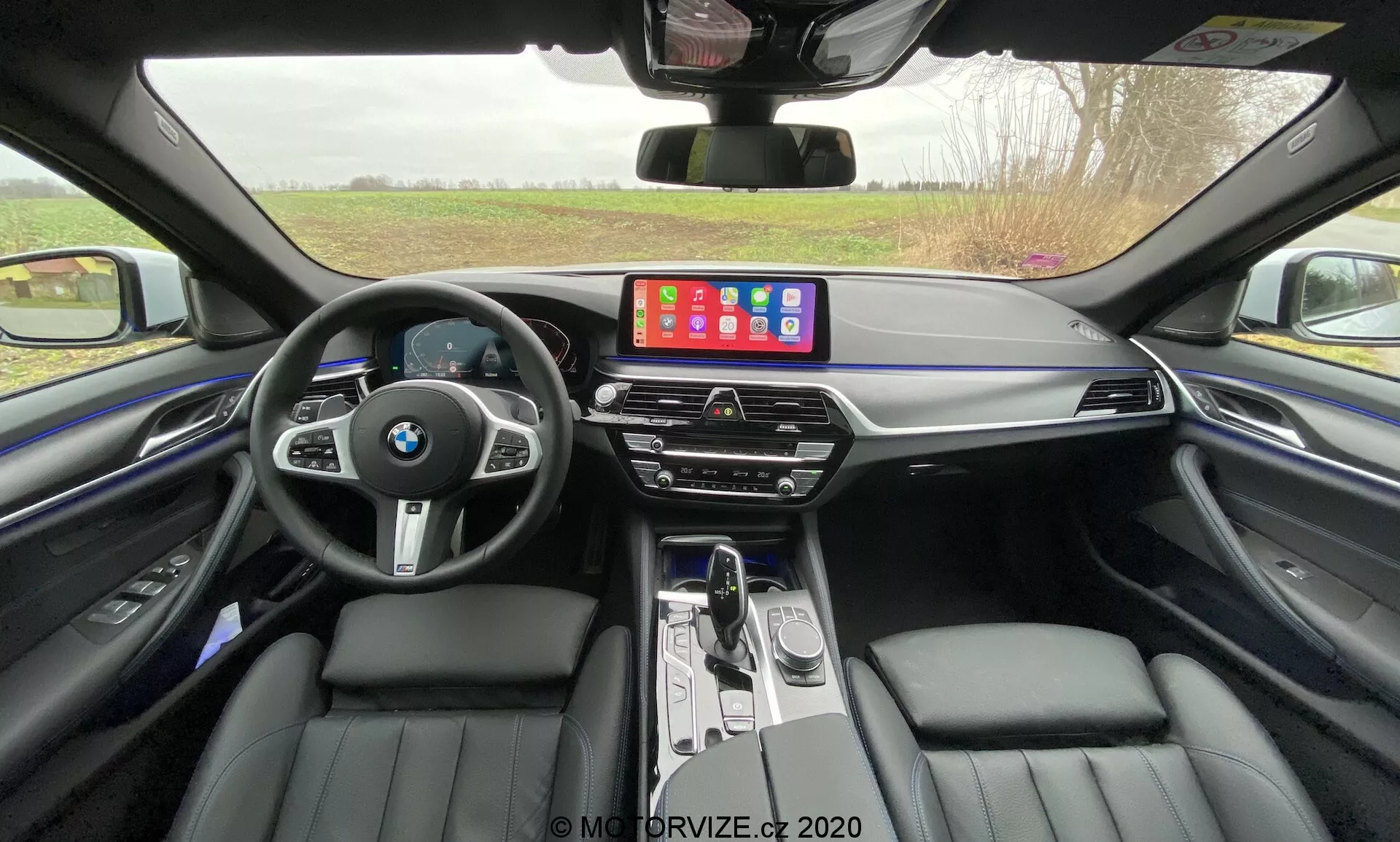 Widok z przodu BMW 520i Touring Steptronic 2020 w eleganckim metalicznym wykończeniu, ukazujący jego elegancki design, zaawansowane reflektory LED i kultową nerkową osłonę chłodnicy w nowoczesnym miejskim otoczeniu.