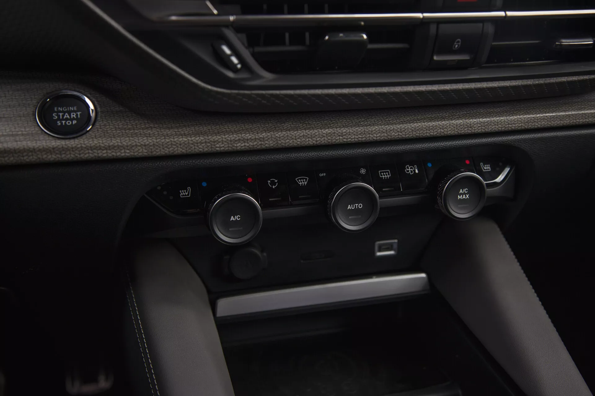 Zbliżony widok wnętrza Citroen C5-X 2022 z przyciskiem start/stop bezkluczykowego zapłonu i zaawansowanym systemem kontroli klimatu z automatyczną regulacją temperatury i opcjami recyrkulacji powietrza.