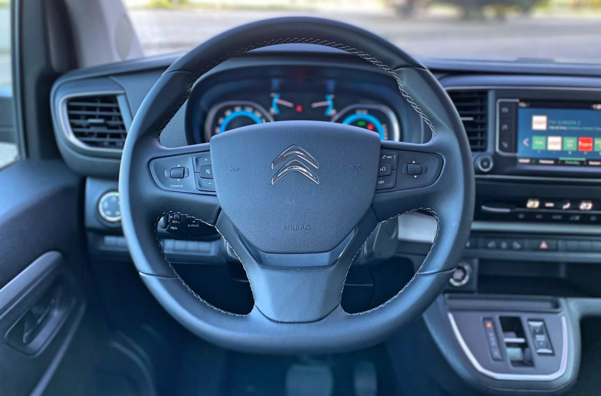 Zbliżony widok wnętrza Citroën Spacetourer 2016, skupiający się na kierownicy z przyciskami wielofunkcyjnymi, logo Citroëna oraz wskaźnikach deski rozdzielczej w tym prędkościomierzu, obrotomierzu i wyświetlaczu cyfrowym.