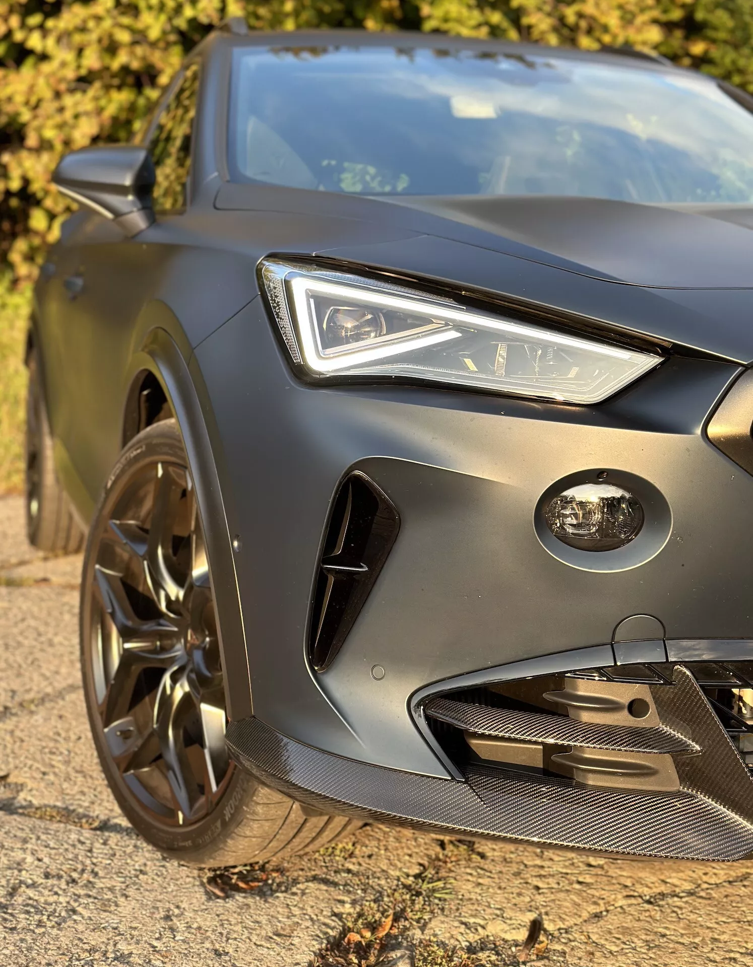 Zbliżenie na przedni lewy kwadrant Cupra Formentor 2020 z LED-owym reflektorem, rzeźbioną maską, przednim zderzakiem o charakterze sportowym oraz sportowym kołem ze stopu