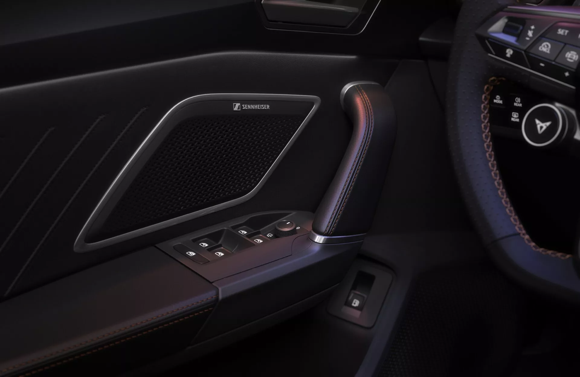 Zbliżenie na panel drzwi po stronie kierowcy w Cupra Leon 2024 (pierwsza generacja facelift), ukazując elegancką klamkę o teksturze przypominającej skórę, metaliczny akcent, podświetlane przyciski do sterowania szybami oraz zintegrowaną kratkę głośnika sugerującą system audio premium, z widocznym w tle rogiem kierownicy z zamontowanymi przyciskami.