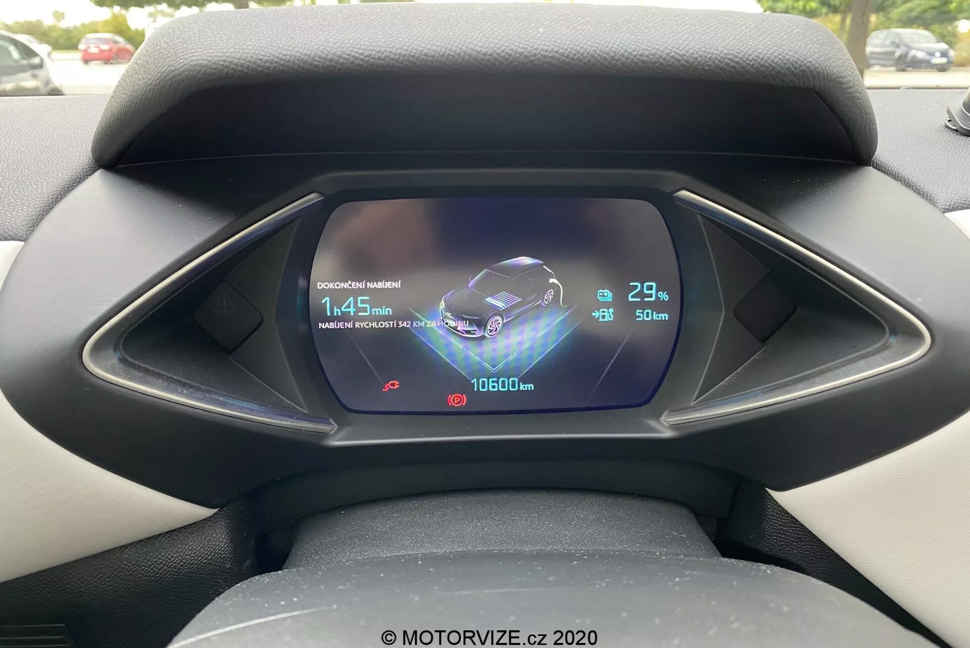Zbliżenie cyfrowego zestawu wskaźników z perspektywy kierowcy w samochodzie DS Automobiles DS 3 2019 (DS 3 Crossback E-Tense). Wyświetlacz LCD/TFT pokazuje skomplikowaną grafikę, w tym animowaną reprezentację pojazdu, symbol Bluetooth, wskaźnik czasu ładowania wynoszący 1:45 min przy stanie naładowania 29%, temperaturę zewnętrzną 23°C, odczyt licznika kilometrów 10600 km oraz wskaźnik poziomu paliwa prawie pełen z szacowanym zasięgiem 50 km.