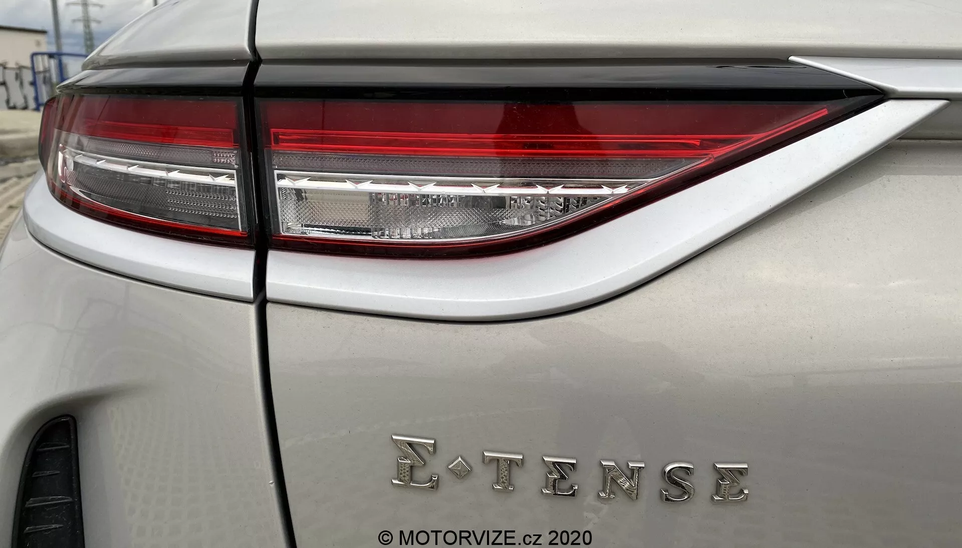 Zbliżenie tylnego panelu pojazdu DS Automobiles DS-3 2019 (DS-3 Crossback E-Tense) z nowoczesnymi i wyrafinowanymi tylnymi światłami LED oraz emblematem E-TENSE, wskazującym na technologię elektryczną lub hybrydową. Samochód ma neutralny kolor nadwozia z matowym lub satynowym wykończeniem.