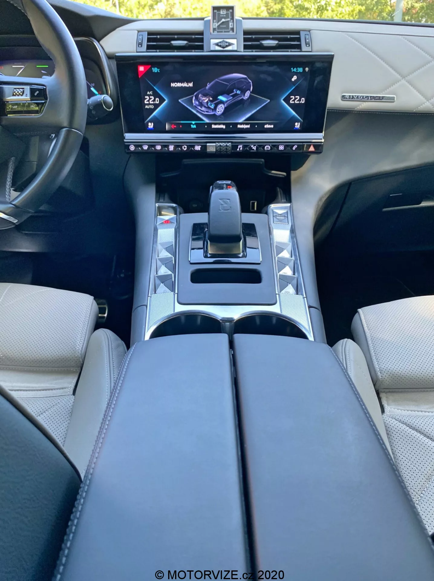 Widok wnętrza DS Automobiles DS 7 Crossback z 2018 roku z perspektywy kierowcy, prezentujący centralną konsolę z wysokiej rozdzielczości ekranem dotykowym systemu info-rozrywki, nowoczesnym selektorem biegów, przyciskami trybów jazdy, uchwytami na kubki, tapicerowanymi podłokietnikami i kierownicą z przyciskami sterującymi, odzwierciedlającymi zaawansowany design i technologię motoryzacyjną.