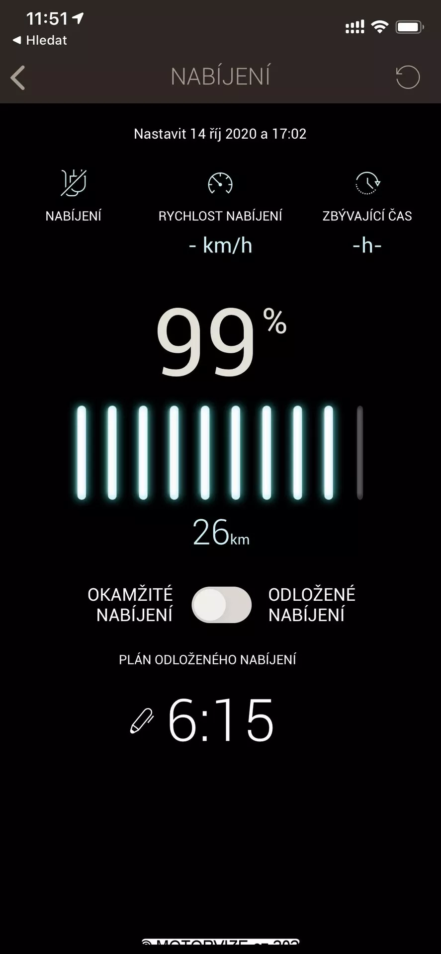 Zrzut ekranu pokazujący stan ładowania pojazdu elektrycznego w aplikacji mobilnej lub interfejsie systemu infotainment. Na górze wyświetla się ikona baterii i słowo 'NABIJENI,' które oznacza ładowanie po czesku. Poniżej widoczna jest konfiguracja dla 14 października 2020 roku o godz. 17:02. Pasek stanu baterii jest prawie w pełni naładowany na 99%, z wskaźnikiem zasięgu wynoszącym 26 km. Dwa przyciski z napisami 'Natychmiastowe ładowanie' i 'Opóźnione ładowanie' umożliwiają kontrolowanie czasu ładowania. Na dole wyświetla się zegar pokazujący 6:15 dla opóźnionego ładowania. Interfejs ma czysty design z czarnym tłem oraz białym i zielonym tekstem, idealnym dla poprawy czytelności.