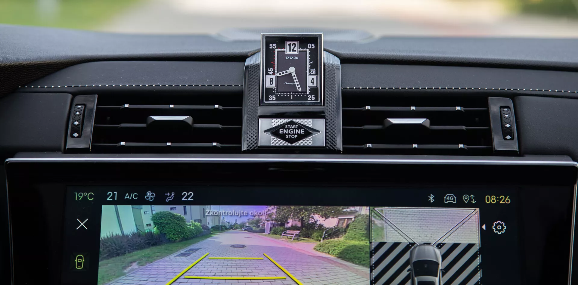 Widok wnętrza DS Automobiles DS-7 2022 prezentujący deske rozdzielczą, luksusowy zegar analogowy i centralny wyświetlacz systemu infotainment z kamerą cofania i funkcją asysty parkowania