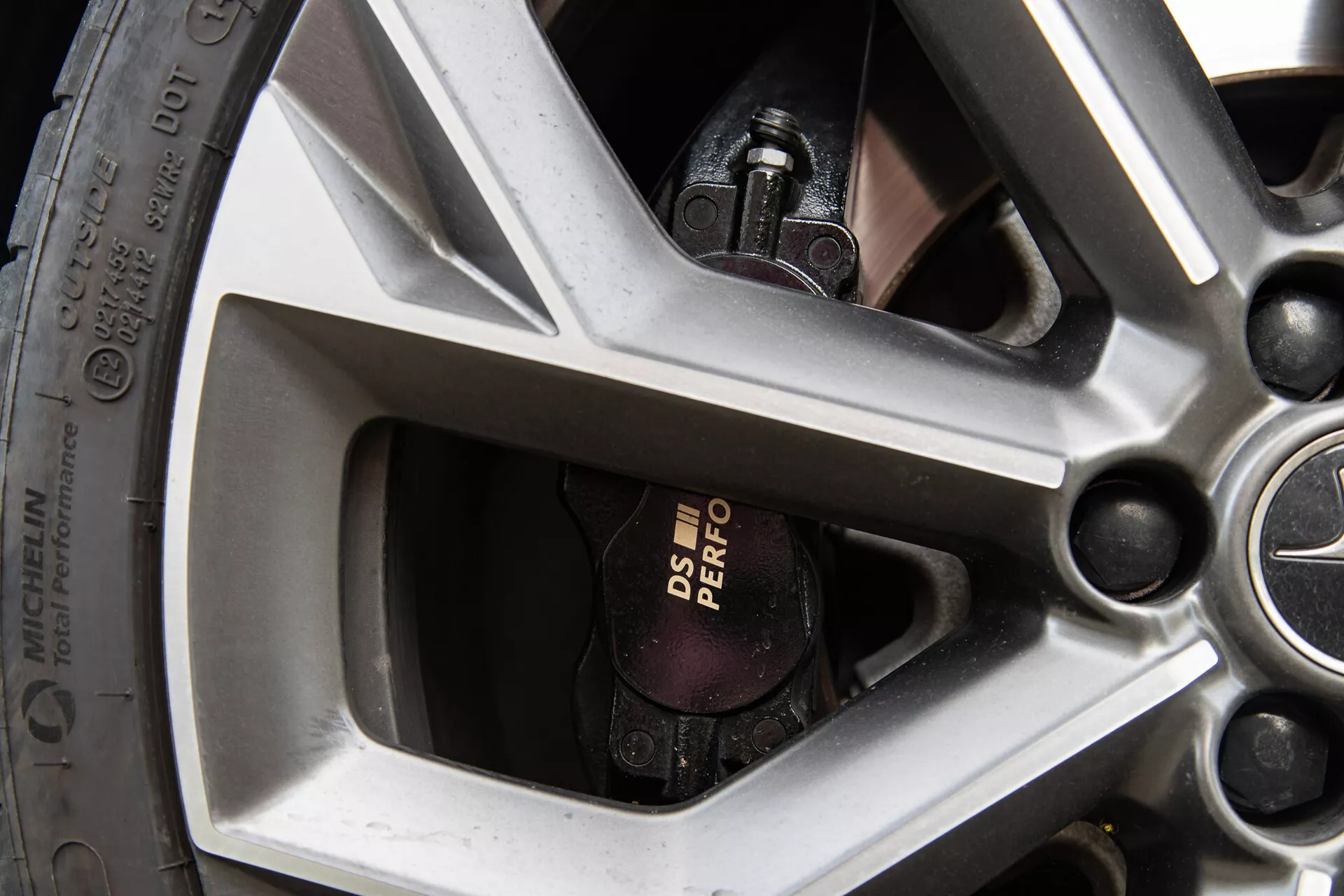 Zbliżone zdjęcie koła DS Automobiles DS-7 2022 z pięcioramiennym wzorem, widocznym zaciskiem hamulcowym Brembo i specyfikacją opon o wysokich osiągach.