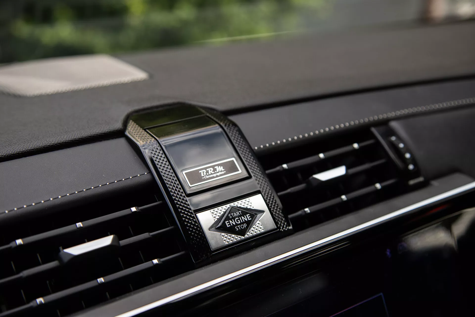 Zbliżenie na środkową konsolę DS Automobiles DS-7 2022 z luksusowym zegarem analogowym i nawiewami, podkreślające wysokiej jakości materiały i nowoczesny design