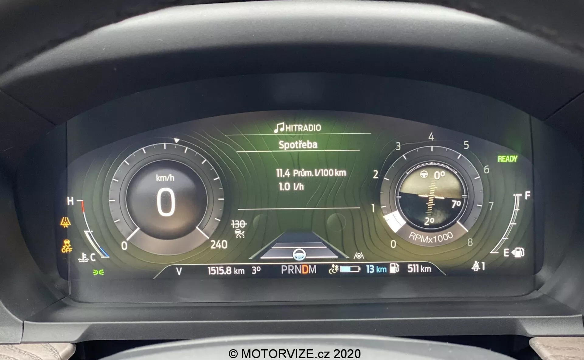 Zbliżenie zaawansowanego cyfrowego zestawu wskaźników Forda Explorera 2019 z perspektywy kierowcy, z cyfrowym prędkościomierzem w kilometrach na godzinę, symulowanym analogowym obrotomierzem, wyświetlaczem z wieloma informacjami o mediach i podróży, odczytem licznika kilometrów wynoszącym 15158 km, wskaźnikiem chłodnego silnika, prawie pełnym wskaźnikiem paliwa i kilkoma kontrolkami ostrzegawczymi.
