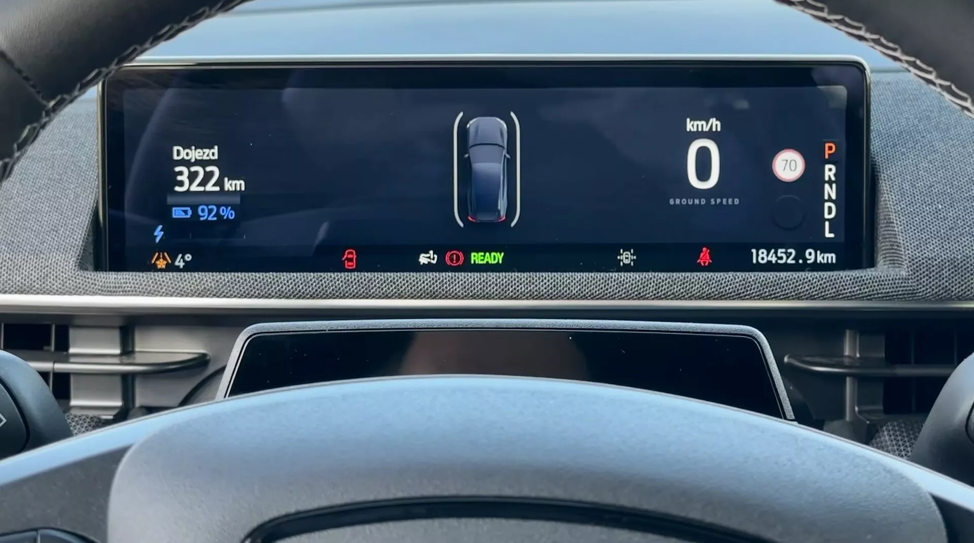 Wyświetlacz cyfrowy deski rozdzielczej Ford Mustang Mach-E 2020 z perspektywy kierowcy pokazujący prędkość pojazdu 0 km/h, pozostały ładunek baterii 92%, całkowity przejechany dystans 18452,9 km, oraz samochód w trybie Parkowania, z wskaźnikami dla stanu pojazdu elektrycznego i zaawansowanych systemów wspomagania kierowcy