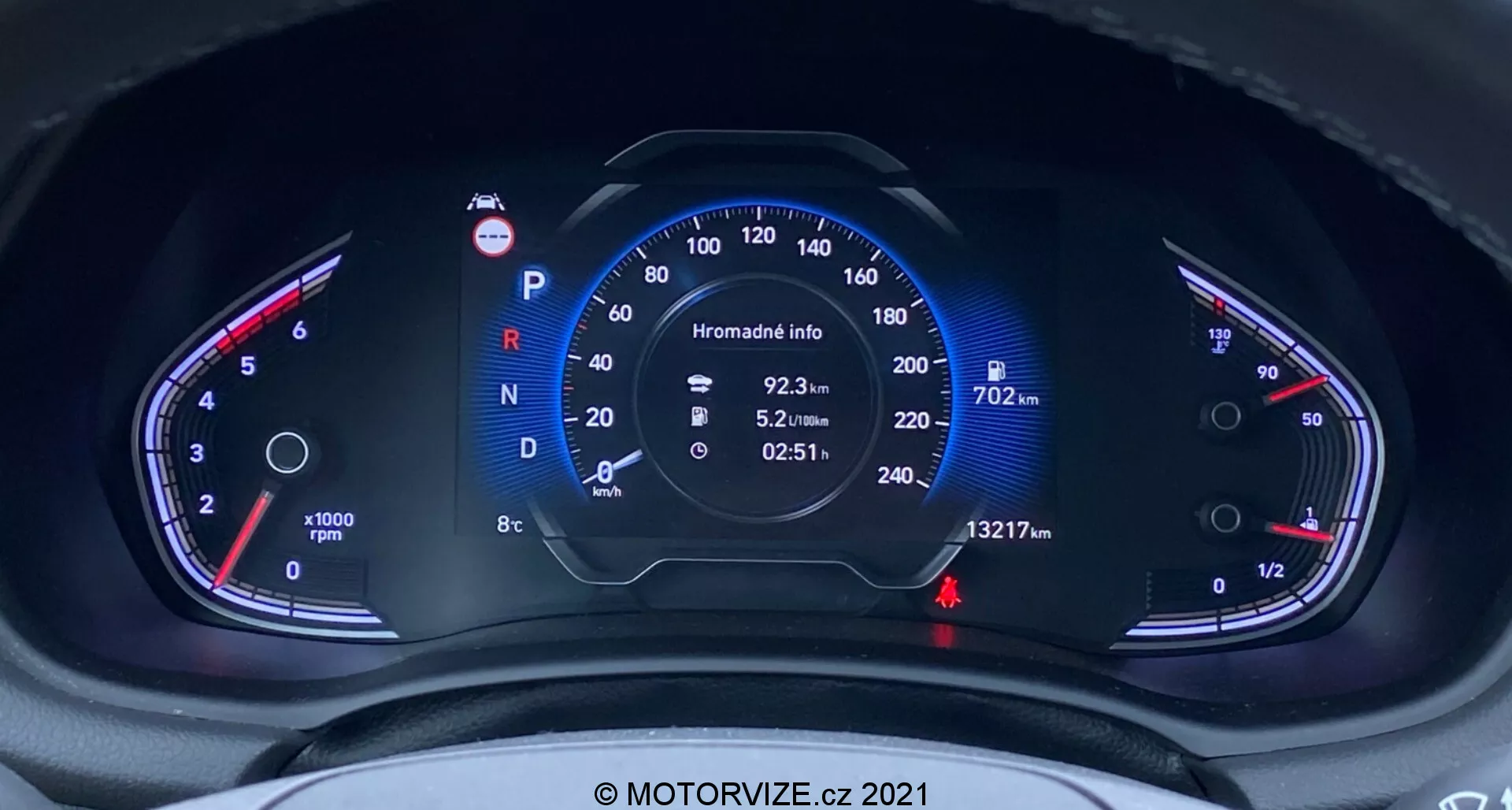 Zbliżenie na cyfrowy zestaw wskaźników Hyundai i30 2020 (i30-kombi) z perspektywy kierowcy, skupiając się na prędkościomierzu (do 260 km/h) i obrotomierzu (do 8000 rpm) z dodatkowymi wskaźnikami temperatury i poziomu paliwa. Centralny wyświetlacz pokazuje samochód w trybie Parkowania, dane komputera pokładowego i odczyt licznika kilometrów wynoszący 13,217 km.