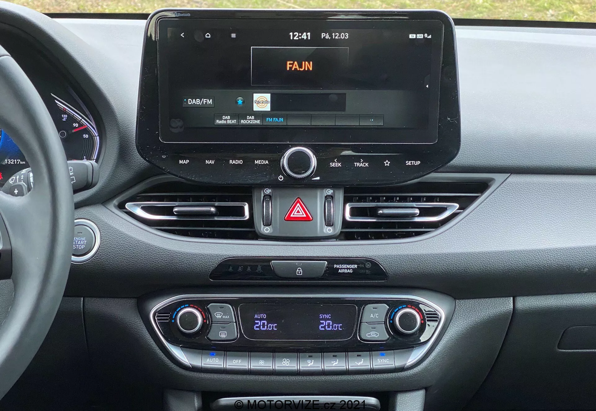 Centralna konsola Hyundai i30 2020 z nowoczesnym systemem info-rozrywki z ekranem dotykowym, interfejsem radiowym, klimatyzacją dwustrefową i nawiewami z metalowym wykończeniem.