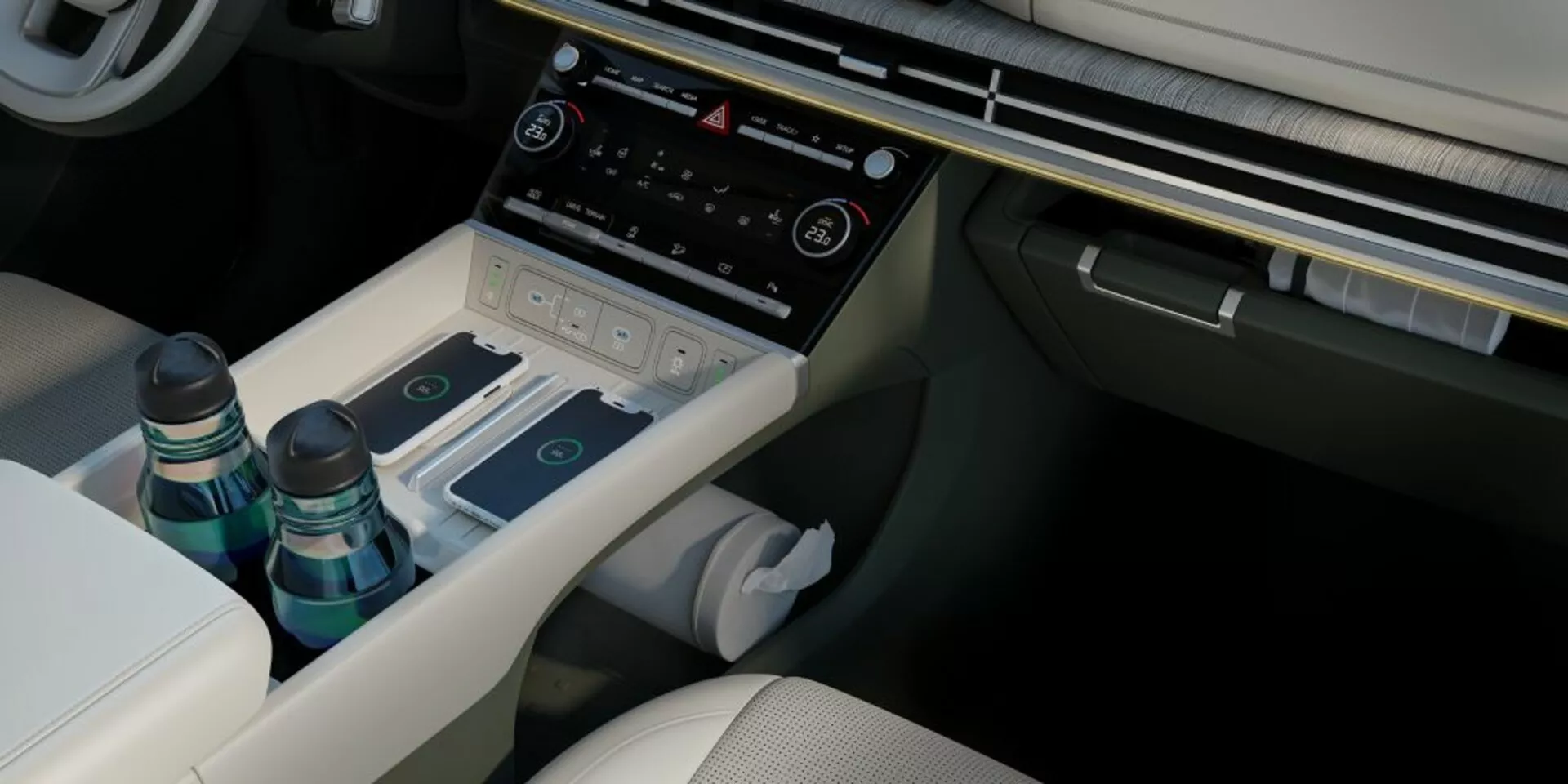 Widok wnętrza konsoli centralnej Hyundai Santa-Fe 2024 (5. generacja) z nieco podwyższonego kąta, ukazujący fotel kierowcy w jasnej tapicerce z widocznymi szwami, otwarty środkowy podłokietnik ze schowkiem na dwie butelki i wykończeniem przypominającym drewno, biały sanitarny chusteczek częściowo widoczny poniżej konsoli centralnej, elegancki selektor biegów na tunelu przekładniowym, różne przyciski sterowania dla trybów jazdy lub ustawień zawieszenia, zaawansowany system klimatyzacji z wyświetlaczem i przyciskami dotykowymi, oraz dolną krawędź systemu infotainment. Fotel pasażera jest podobny do fotela kierowcy pod względem tapicerki. Obraz podkreśla luksusowy design wnętrza pojazdu, materiały premium i funkcje technologiczne takie jak system infotainment, kontrola klimatu, rozwiązania przechowywania, elektroniczny selektor biegów i dostosowywalne ustawienia jazdy.