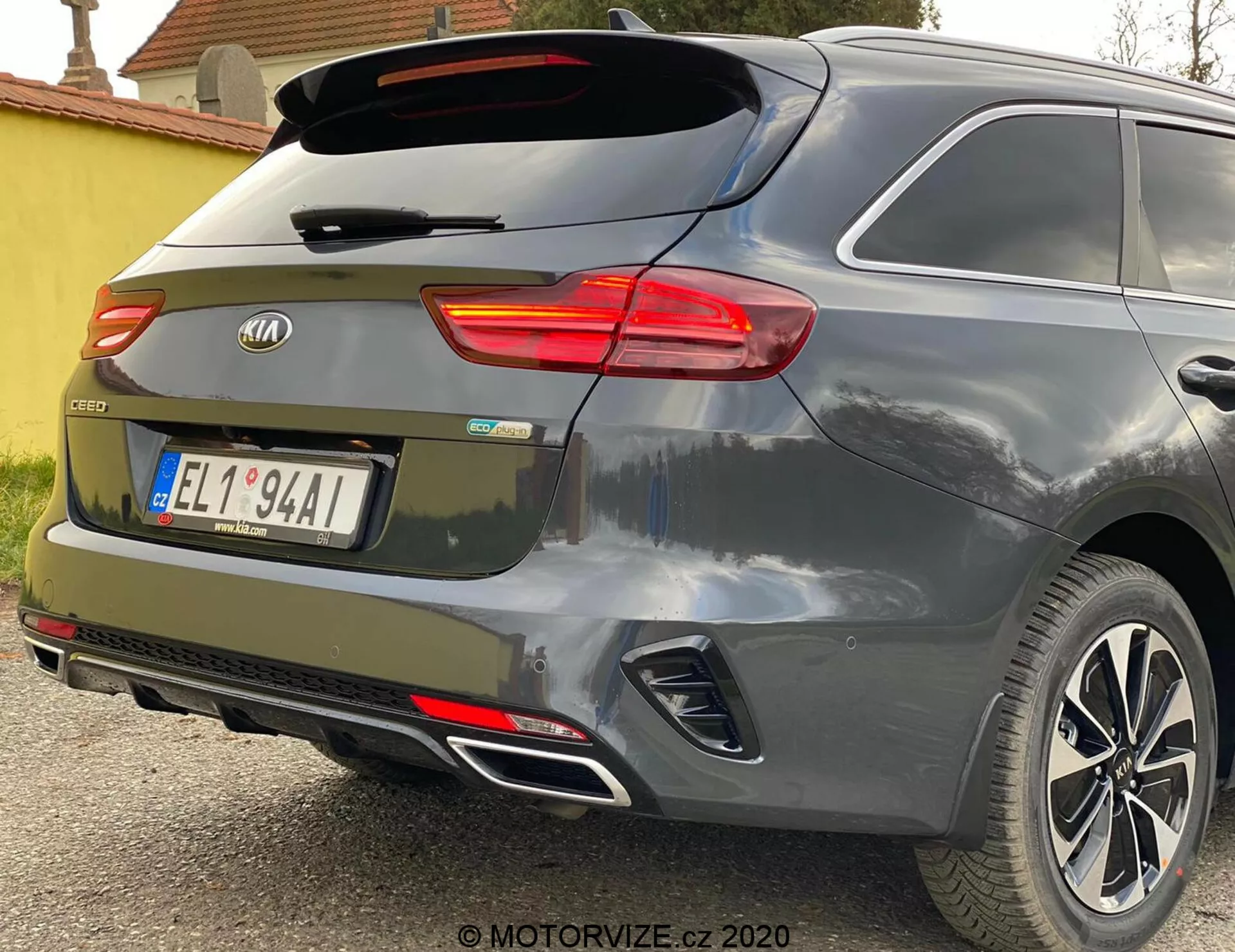Częściowy tylny widok pod kątem Kia Ceed 2018, podkreślający oświetlenie prawej tylnej lampy, tylnej szyby z wycieraczką, klapy bagażnika z emblematem marki i oznaczeniem modelu 'CEED', zintegrowane reflektory w tylnym zderzaku, czujniki parkowania, system podwójnego wydechu i lekkie felgi na metaliczny szary lub srebrny lakier.