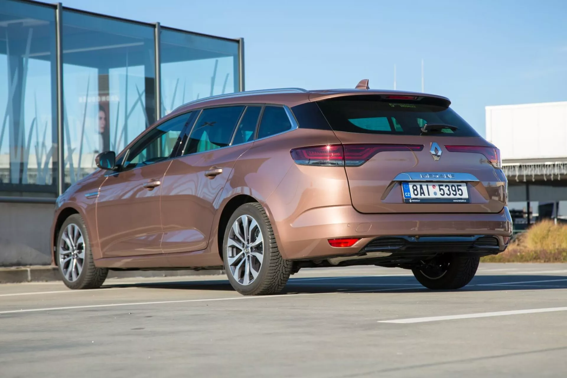 Kombi Kia Ceed 2009 uchwycone z tylnego kąta trzech czwartych podkreślające tylne światła, projekt zderzaka tylnego, rurę wydechową i kontury boczne nadwozia w słoneczny dzień