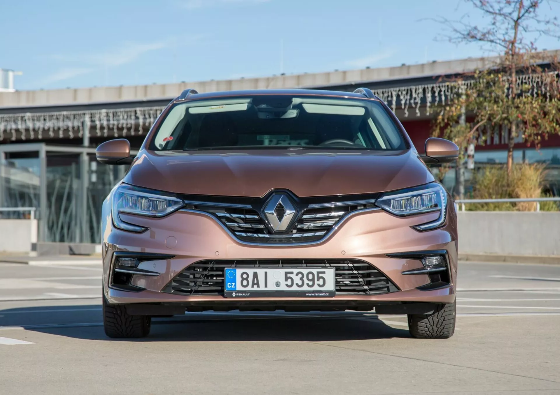 Widok z przodu Kia Cee'd z 2009 roku w metalicznym brązie, z logotypem Renault, reflektorami LED i światłami przeciwmgielnymi, sfotografowany w świetle dziennym, prezentujący nowoczesny design i technologię.