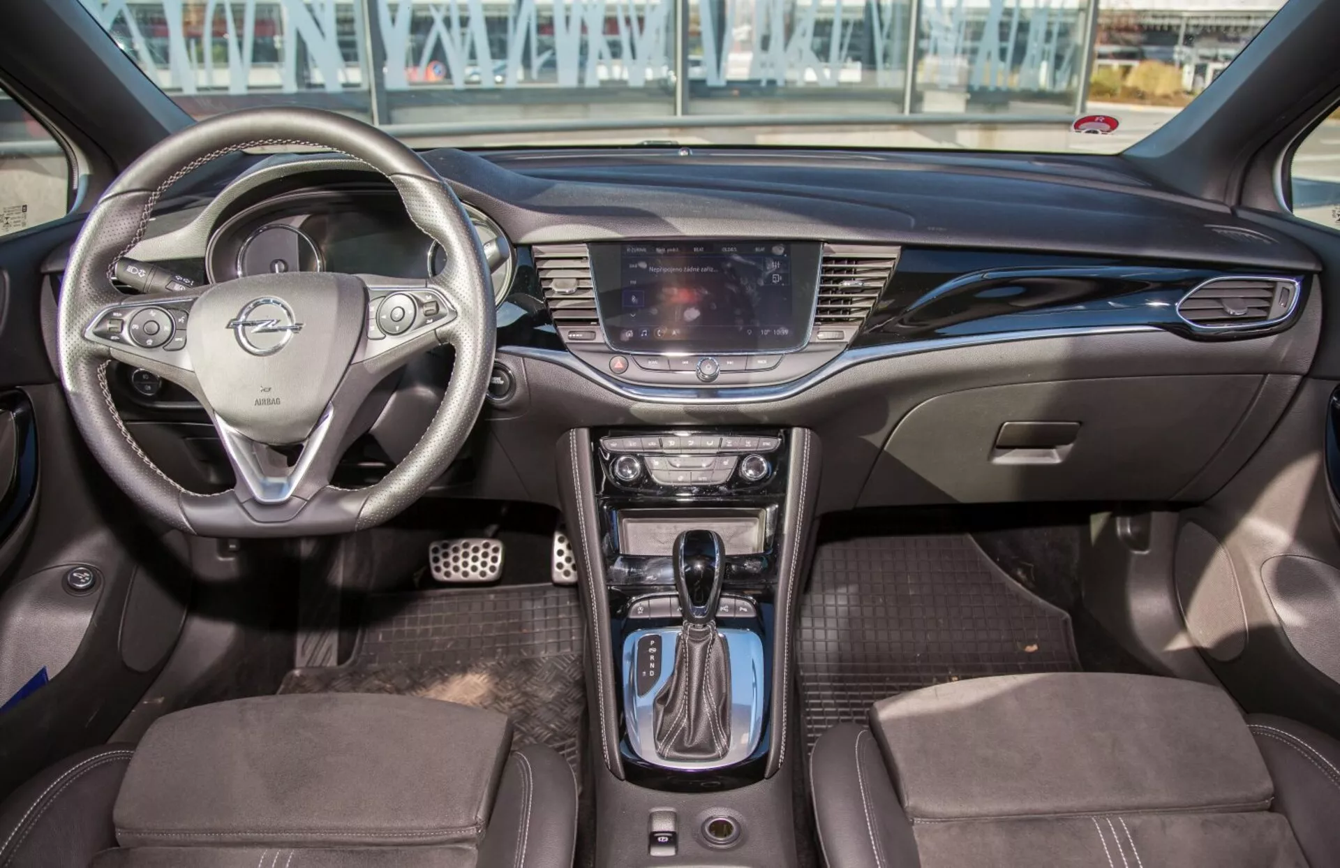 Wnętrze Kia Ceed z 2009 roku z multifunkcyjną kierownicą, systemem infotainment z ekranem dotykowym, klimatyzacją dwustrefową, automatyczną dźwignią zmiany biegów, tapicerką foteli w dwóch kolorach oraz nowoczesnym wzornictwem kabiny z udogodnieniami technologicznymi