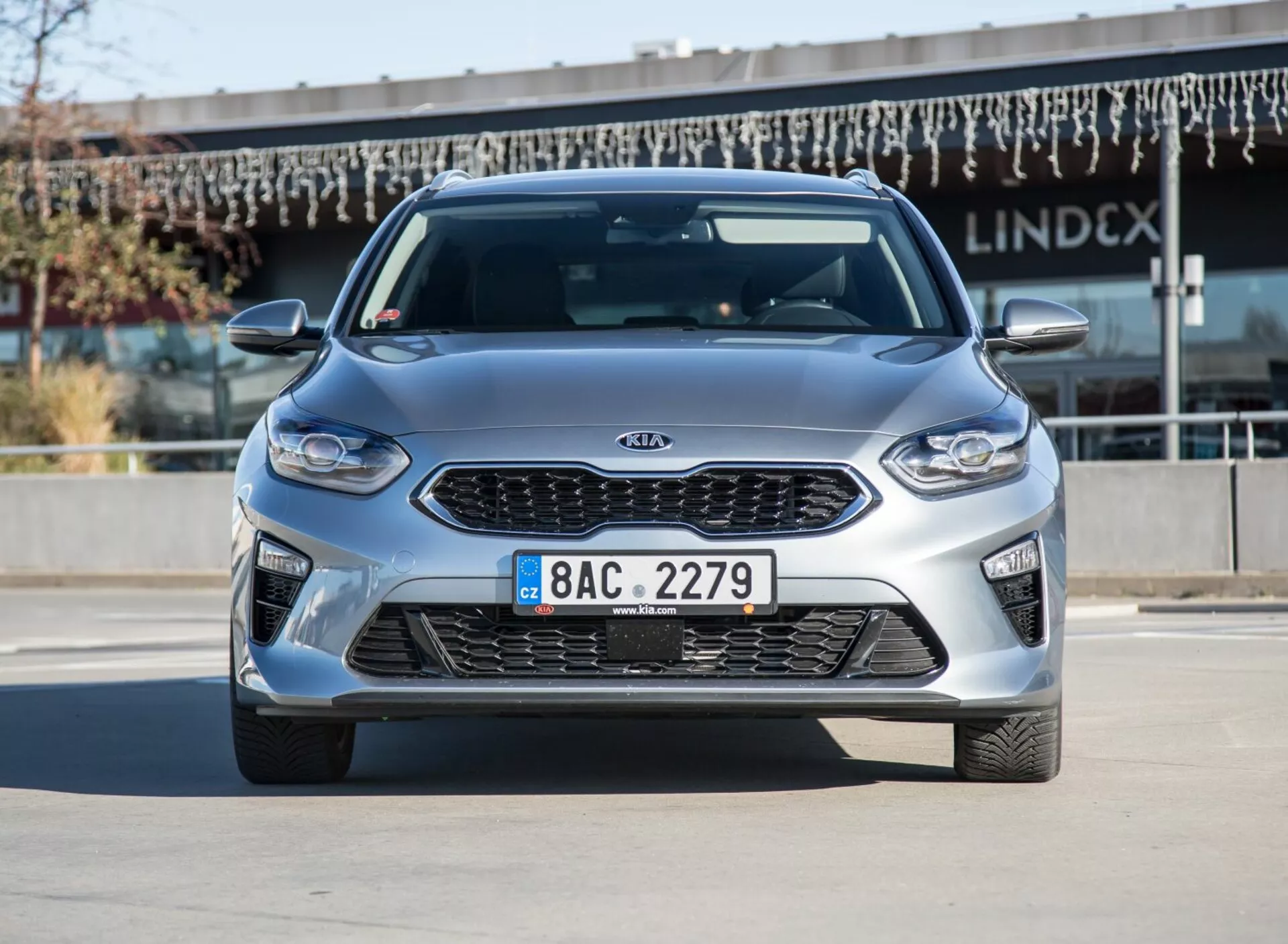 Model Kia Ceed 2009 w metalicznym srebrze, widok z przodu i boku przy jasnym dziennym świetle, pokazujący felgi aluminiowe i aerodynamiczny design