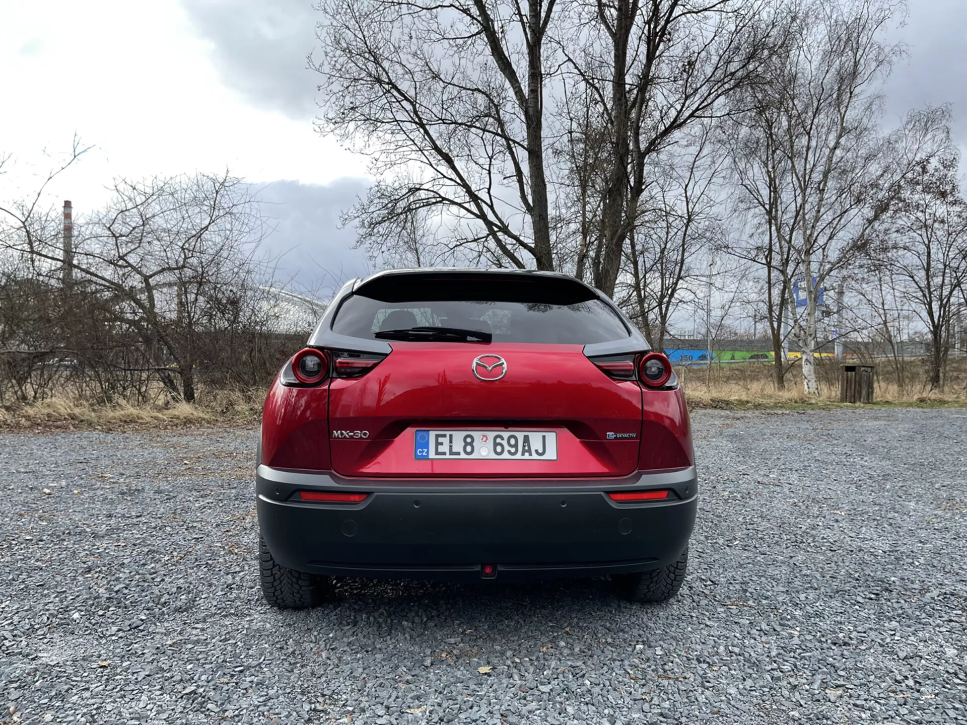 Mazda MX-30 z 2020 roku w eleganckim metalicznym kolorze prezentująca swój nowoczesny design i technologię elektryczną, zaparkowana w malowniczej lokalizacji