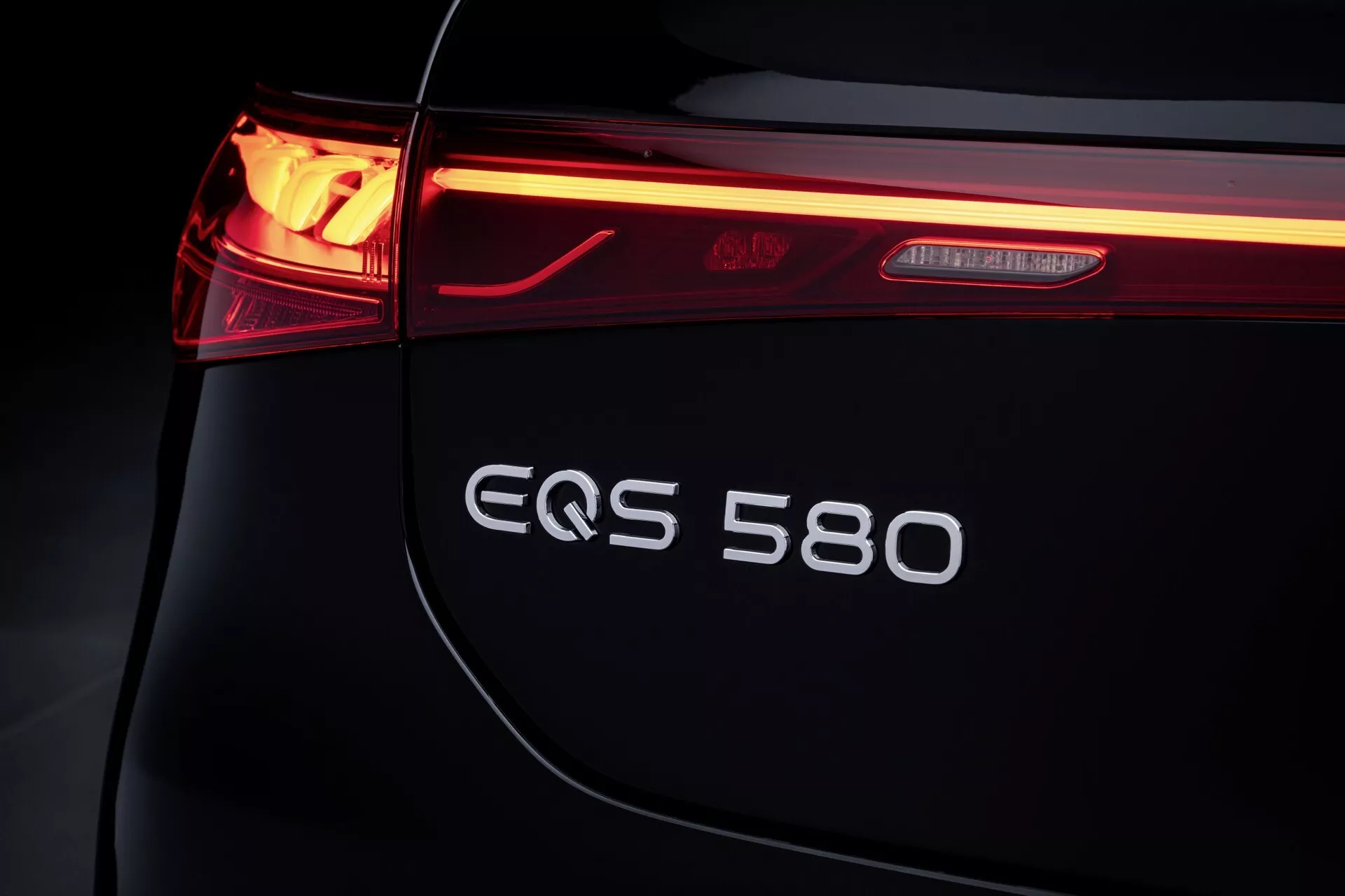Zbliżenie na lewą tylną część Mercedes-Benz EQS 2024, podkreślające diodę LED w tylnym świetle, znaczek EQS 580 i elegancki design bagażnika, symbolizujące luksus i innowacje elektryczne.