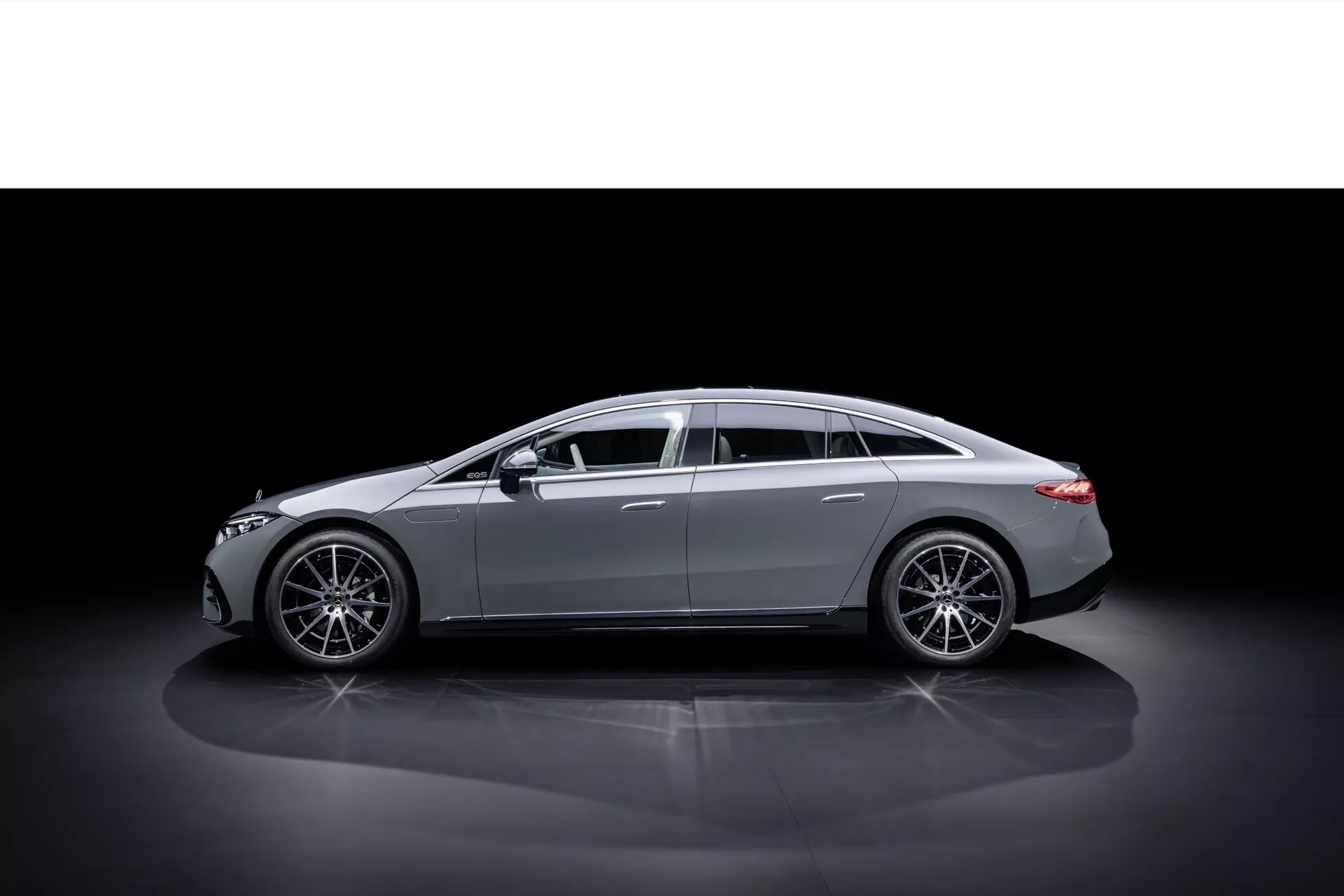 Widok profilowy Mercedes-Benz EQS 2024 po liftingu na ciemnym tle podkreślający elegancki design i linie nadwozia, z nowoczesnymi kołami ze stopu i luksusowymi akcentami chromowanymi