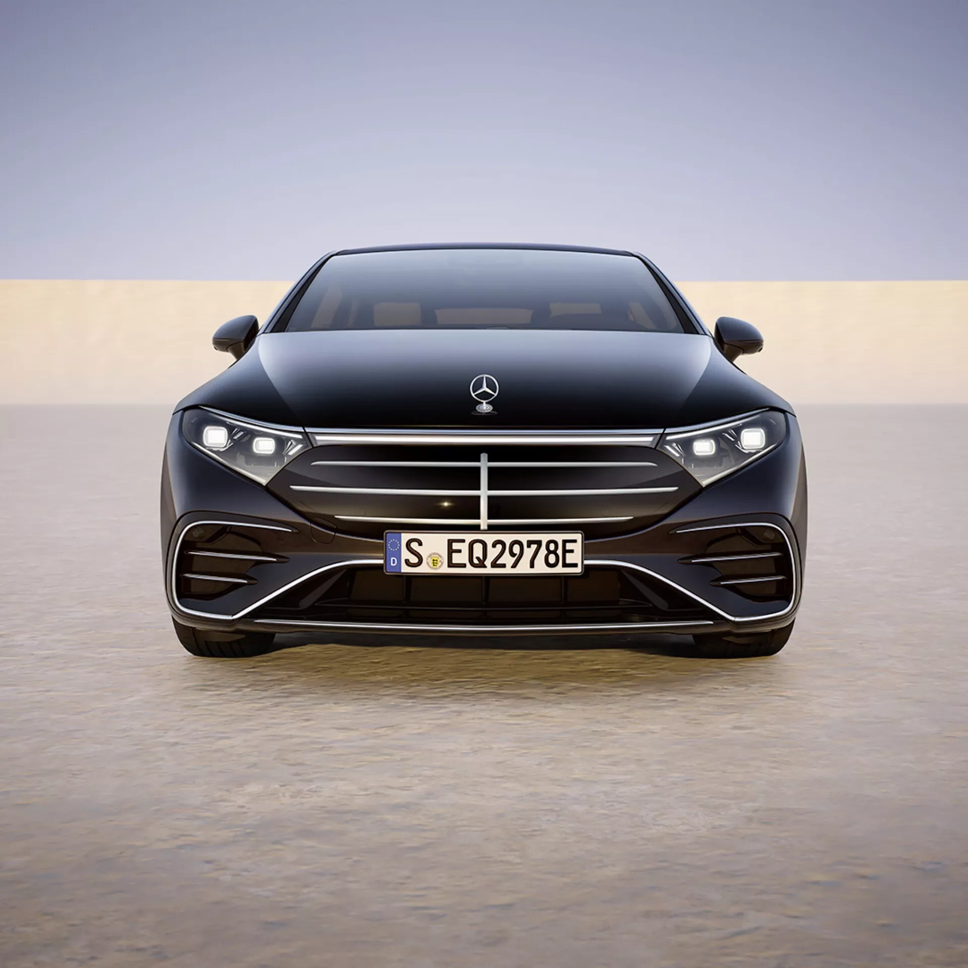 Widok frontalny Mercedes-Benz EQS 2024 (297-facelift) prezentujący pełną szerokość i detale konstrukcyjne takie jak LEDowe reflektory, logo producenta, przedni zderzak o zorientowanym na wydajność designie z dużymi wlotami powietrza, europejską tablicę rejestracyjną, linie aerodynamiczne maski i zaawansowane systemy wspomagania kierowcy zintegrowane w rejonie grilla na tle łagodnego gradientu.