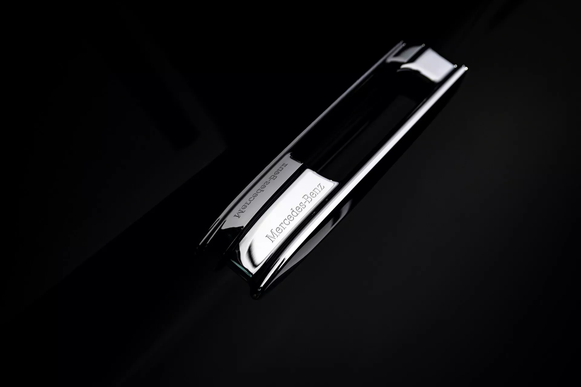 Zbliżenie na emblemat Mercedes-Benz EQS 2024 (297-facelift) z logo gwiazdy trójpunktowej w chromie na ciemnym tle, podkreślający luksusowy projekt motoryzacyjny marki.