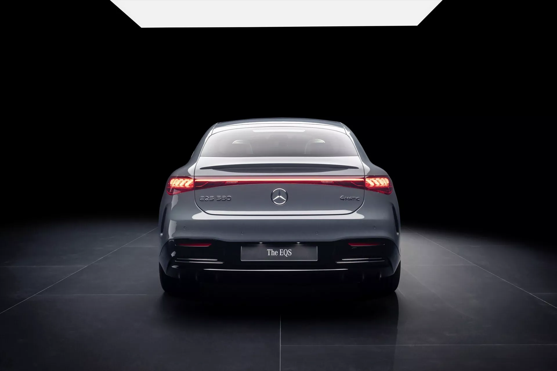 Tył Mercedes-Benz EQS 2024 z eleganckimi światłami LED, chromowanymi akcentami i wyrafinowanym designem w oświetleniu studyjnym