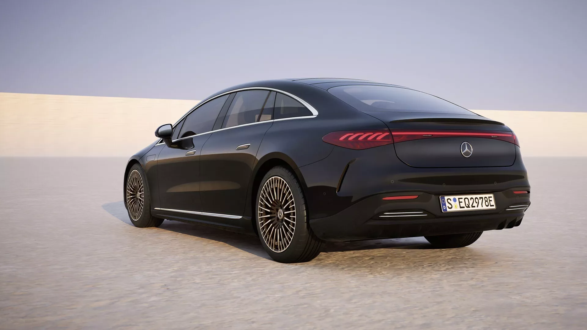 Widok z tyłu ukośnie Mercedes-Benz EQS 2024 (Lifting 297) z diodami LED, aerodynamicznymi kołami ze stopu i linią dachu coupé na piaszczystej równinie