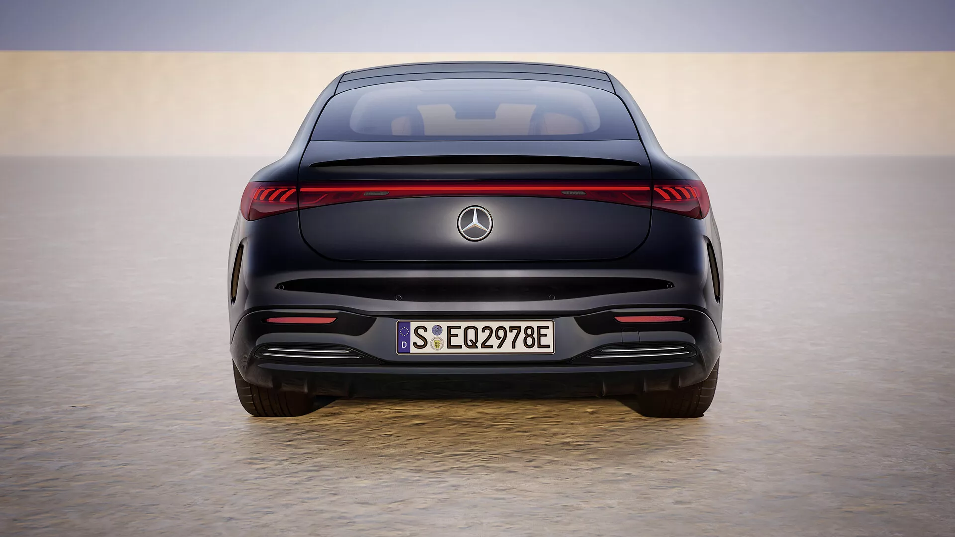Tylny widok modelu Mercedes-Benz EQS 297 po liftingu z 2024 roku na tle gradientowego nieba, prezentujący jego elektryczny design z pasem świetlnym LED, europejską tablicą rejestracyjną S EQ2978E, bez wydechu i czujnikami asystenta parkowania.