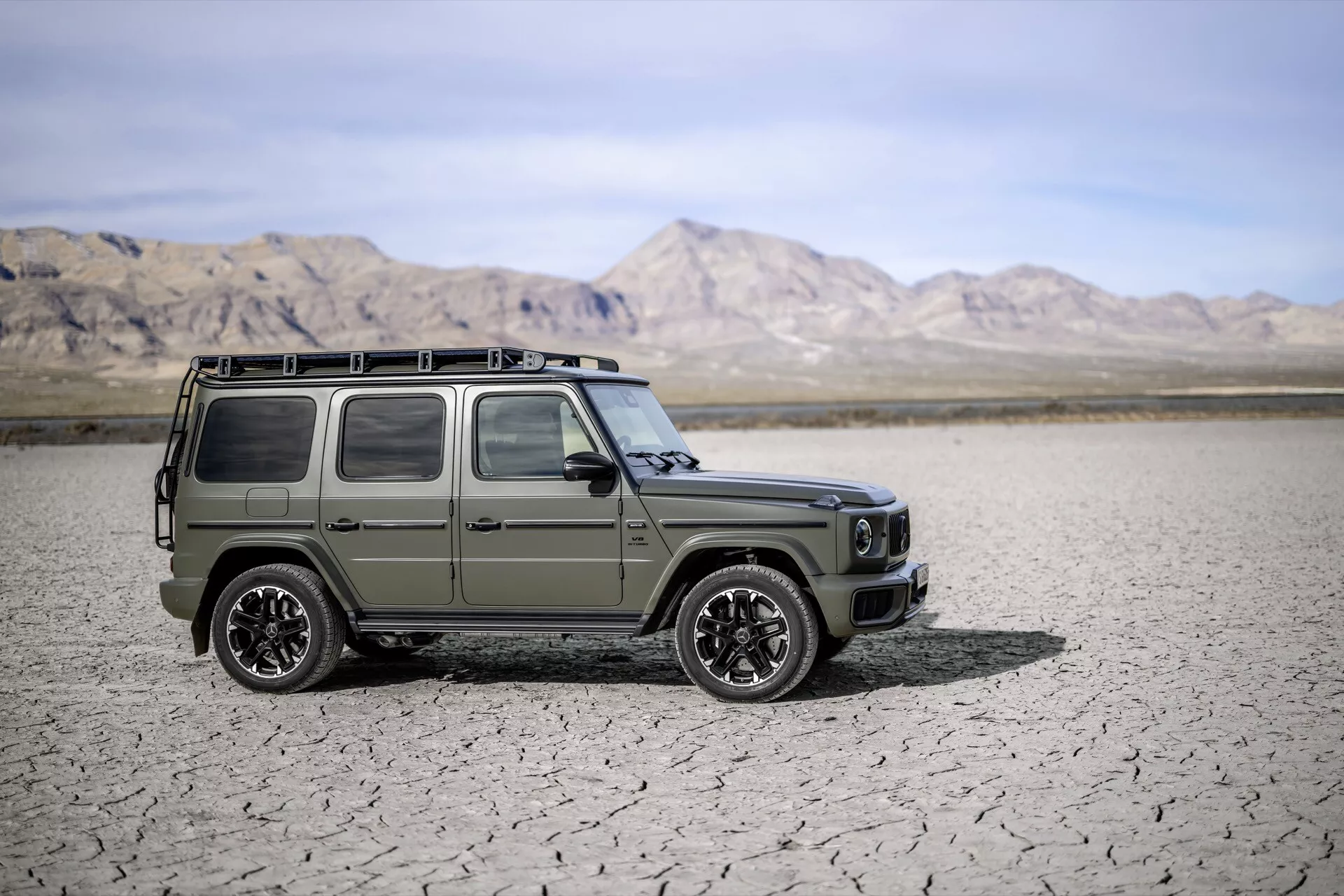 SUV Mercedes-Benz Klasa G rocznik 2024 w matowej oliwkowej zieleni, prezentujący reflektory LED i wytrzymałą konstrukcję na tle pustyni