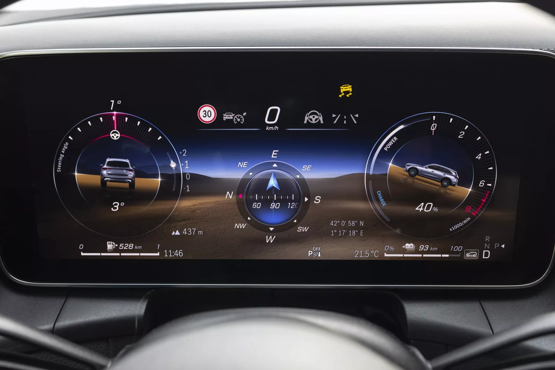 Zbliżenie na cyfrowy zestaw wskaźników w Mercedesie GLC 2022 z perspektywy kierowcy, przedstawiający wysokorozdzielcze metryki pojazdu, takie jak obrotomierz na biegu jałowym, prędkościomierz na 0, kompas cyfrowy wskazujący południe i oznaczenia otwartych drzwi, temperatury zewnętrznej (21,5°C), godziny (11:46), informacji o podróży i przebiegu (5 280 mil), a także różne kontrolki ostrzegawcze dotyczące ciśnienia w oponach, przypomnienia o pasach bezpieczeństwa oraz aktywne systemy ESC i start/stop.
