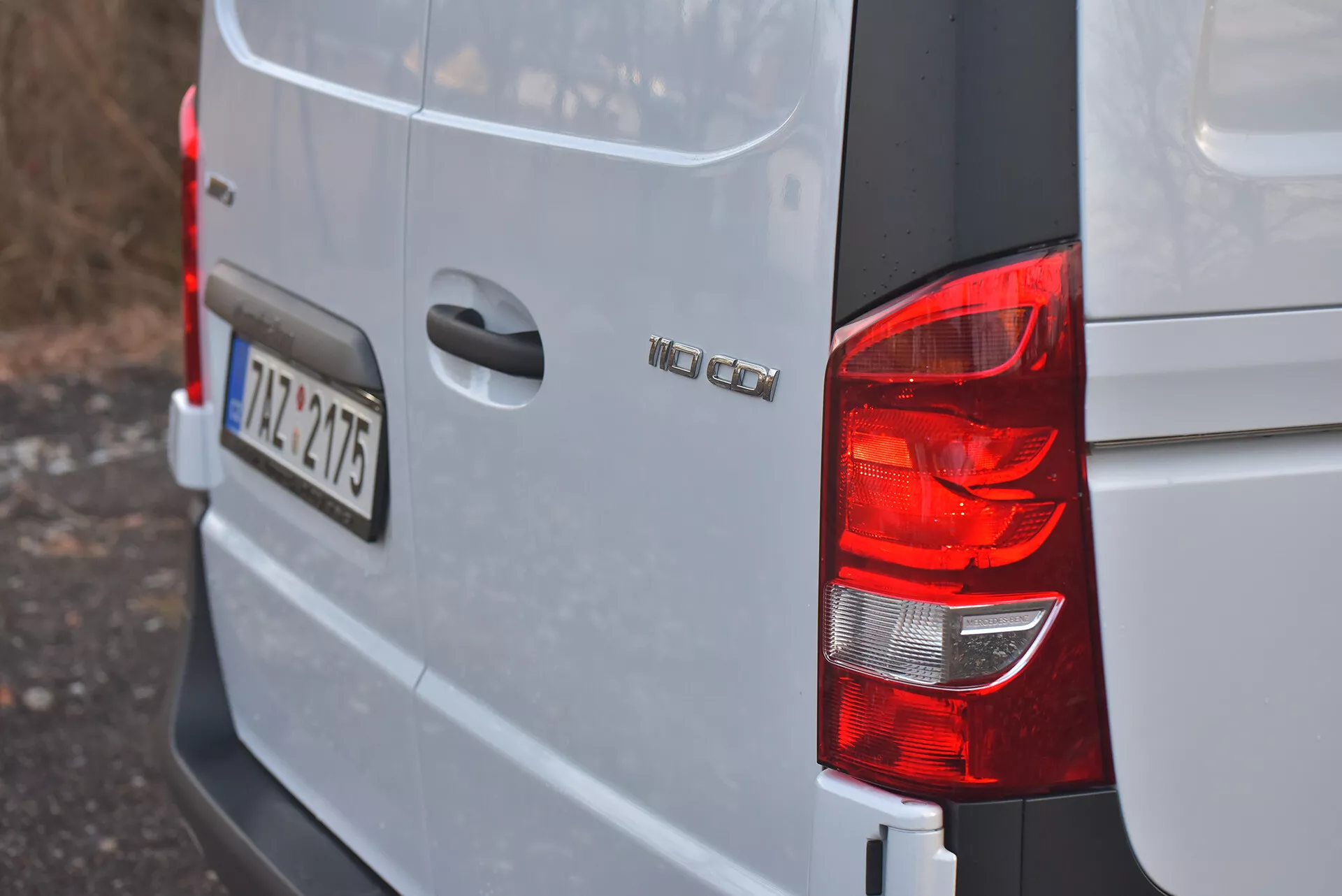 Widok na tylny prawy róg srebrnego lub jasnoszarego Volkswagen Vito 2014 Tourer pokazujący tylne światło, oznaczenie modelu 'VW CADDY', europejską tablicę rejestracyjną '12-TZ-4715' i kwadratową konstrukcję nadwozia typową dla kompaktowych furgonetek ładunkowych.