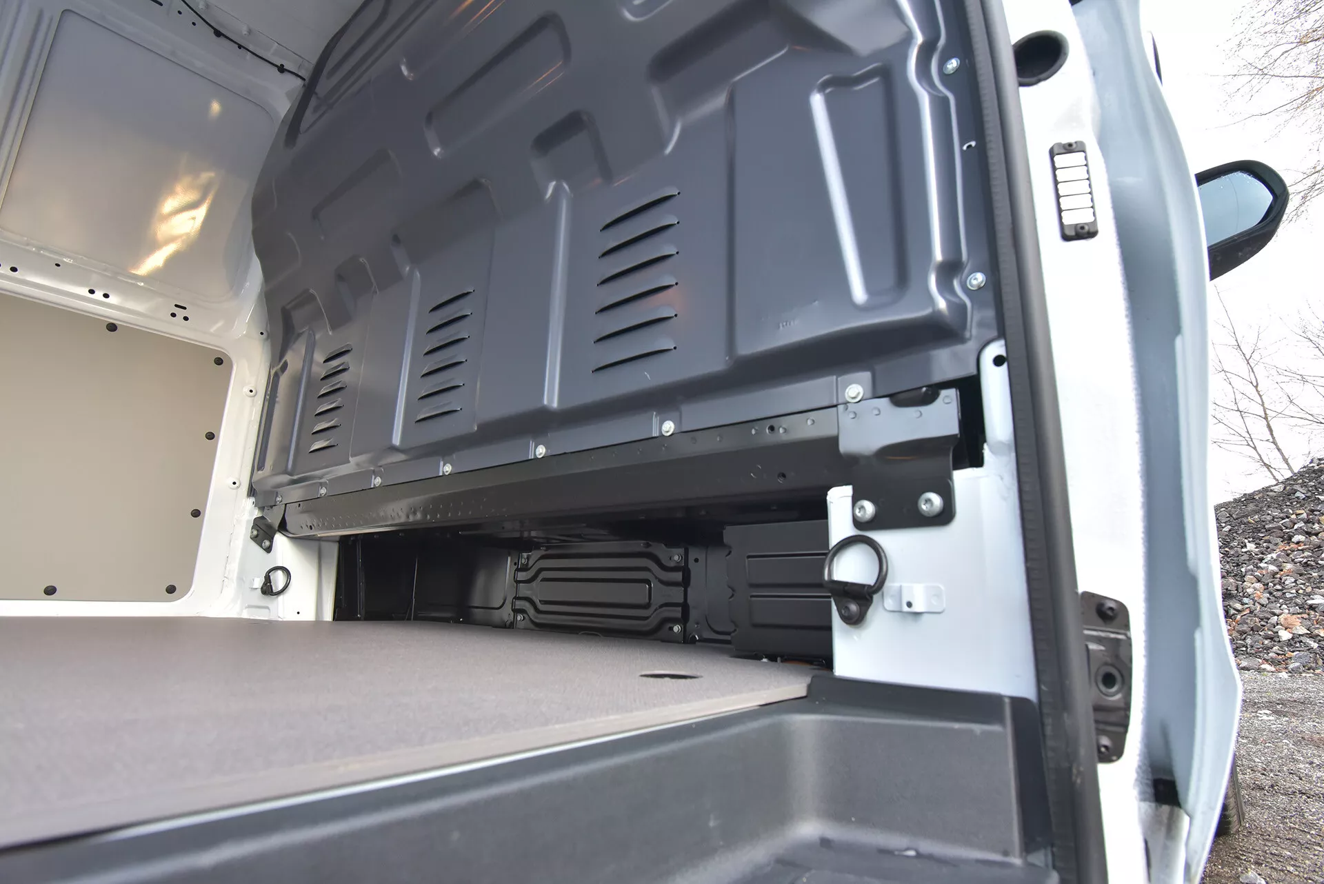 Tylny widok wnętrza dostawczego furgonu Mercedes-Benz Vito Tourer z 2014 roku, podkreślający przestronne, płaskie przestrzenie ładunkowe z otwartymi drzwiami i trwałymi powierzchniami dla efektywnego ładowania i bezpiecznego transportu.