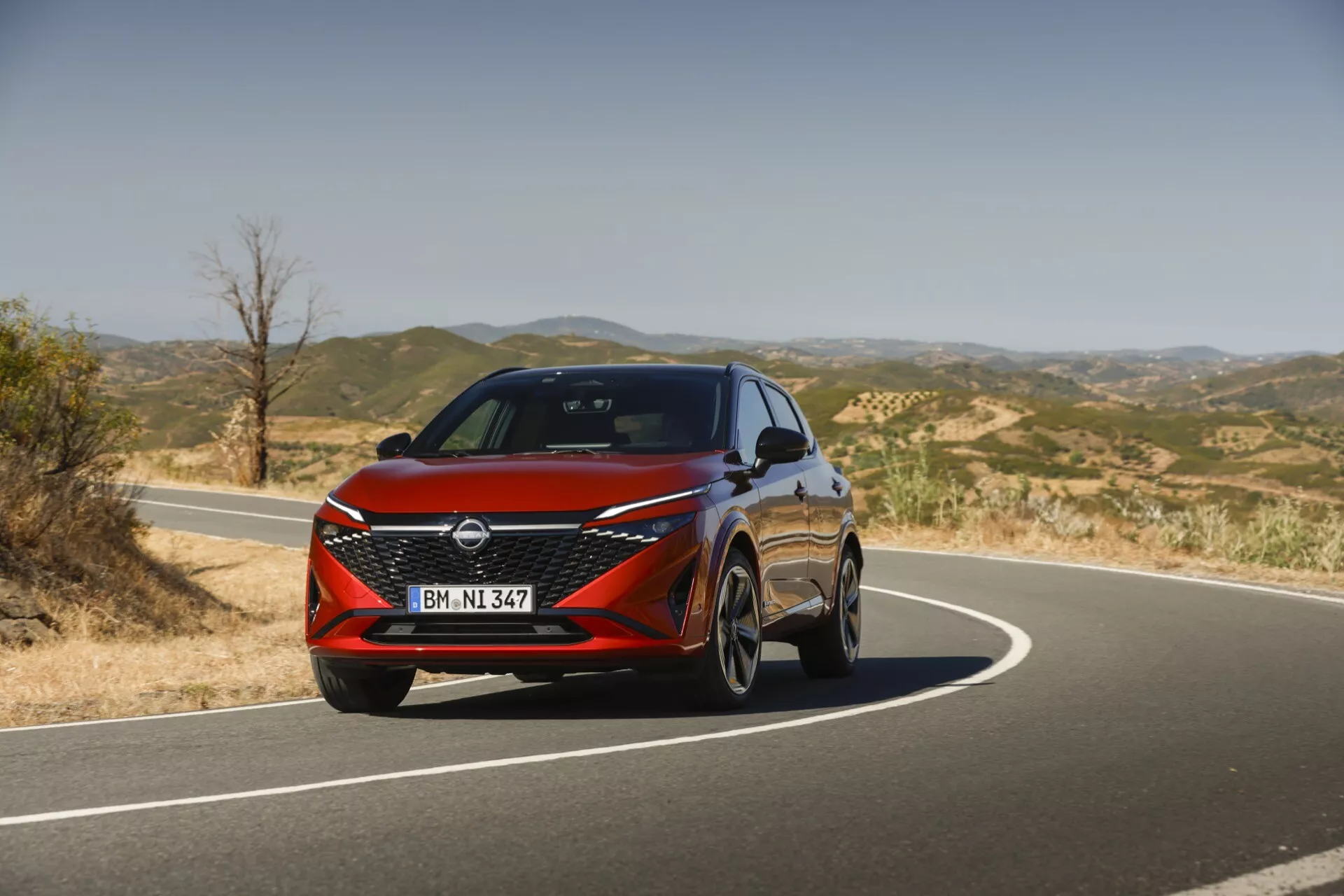 Widok z przodu Nissana Qashqai 2024 J12-facelift prezentujący nowoczesny design z eleganckimi reflektorami LED, odważnym przednim grillem w kształcie litery V-motion i dynamicznymi liniami podkreślającymi jego sportową i wyrafinowaną estetykę.